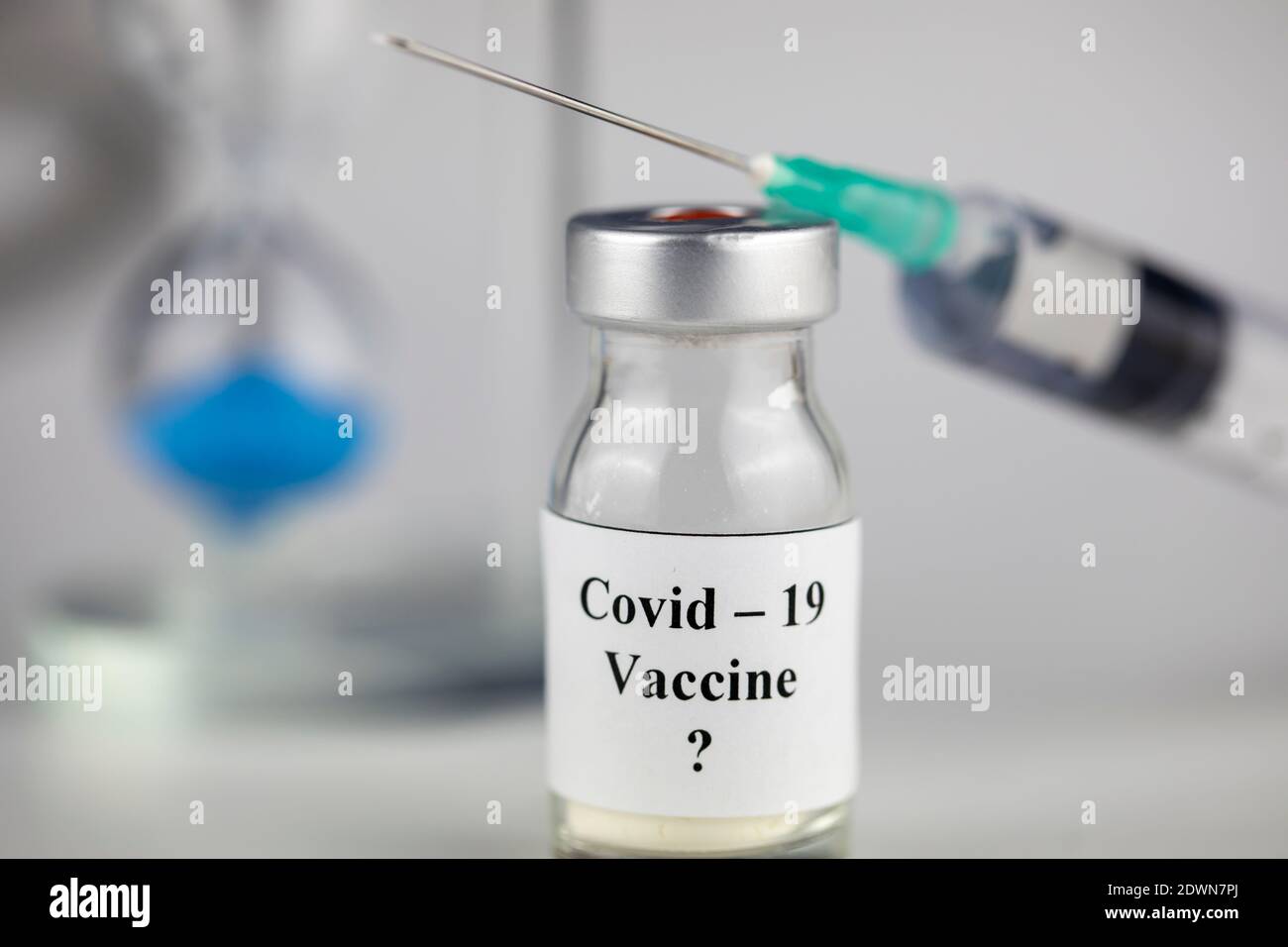 Pandemie und Zeitkonzept , Zeit zu impfen. Impfstoffflasche mit Spritze für Covid-19 und Sanduhr Stockfoto