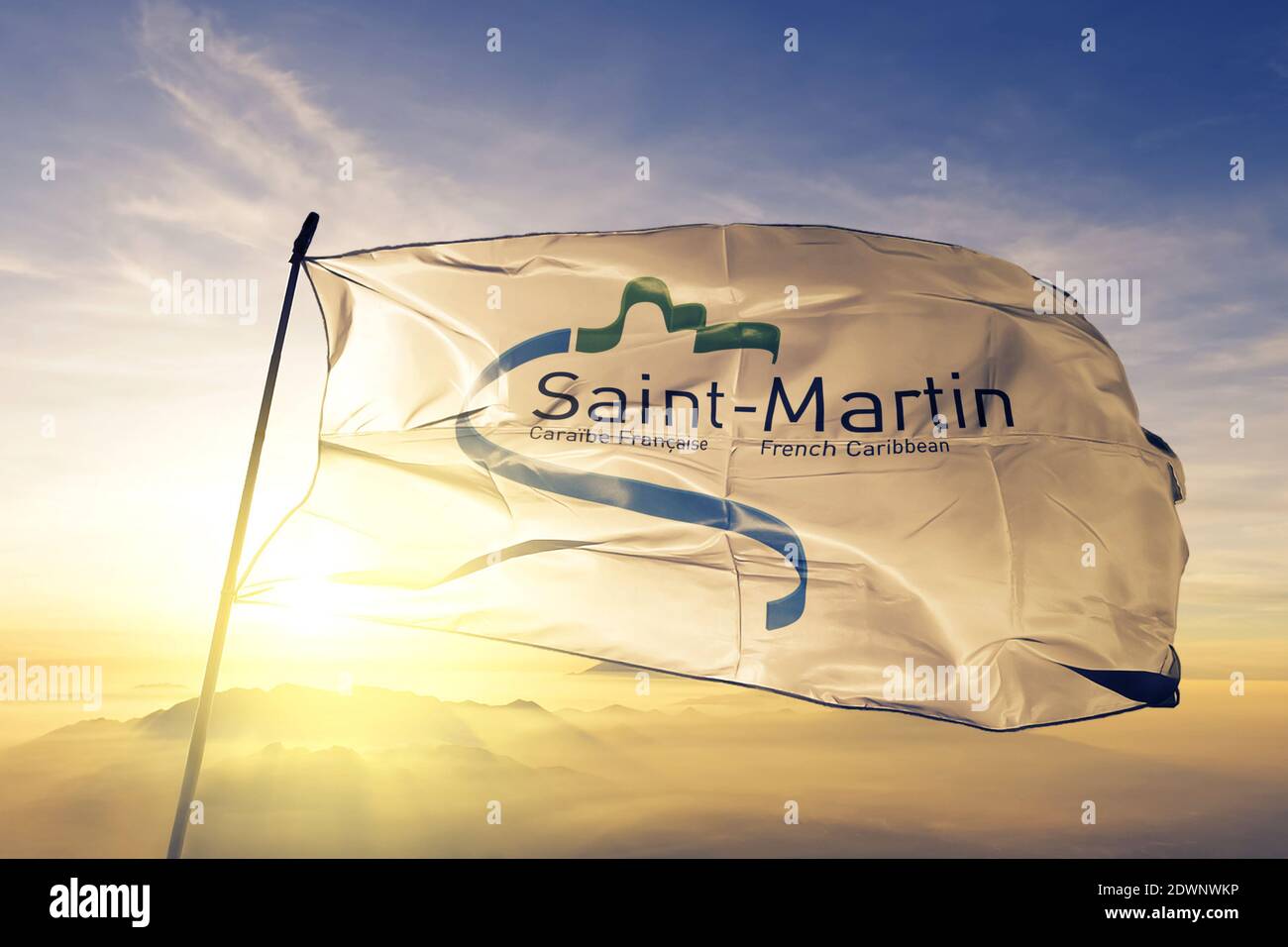 Kollektivität der Saint Martin Flagge winkt auf der Spitze Sonnenaufgang Nebelnebel Stockfoto