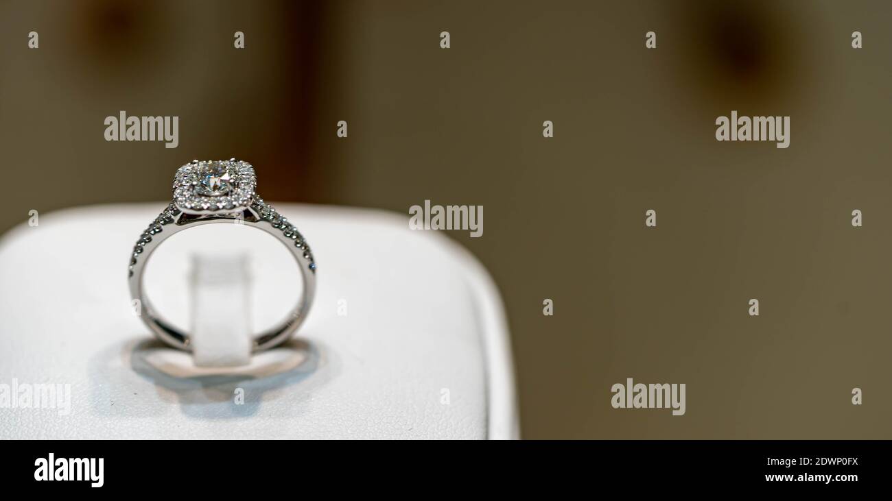 Nahaufnahme von eleganten Diamantring auf einer weißen Box mit verschwommenem Hintergrund. Weicher und selektiver Fokus.Liebe und Hochzeit Konzept. Stockfoto