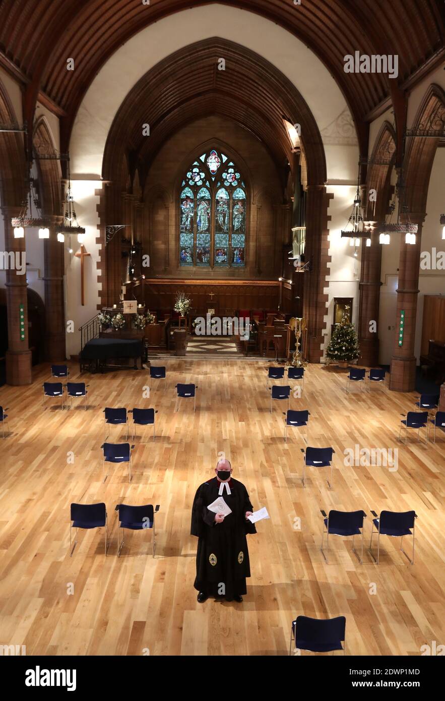 Der ehemalige Moderator der General Assembly Church of Scotland, Rev. Dr. Derek Browning, hält den Weihnachtsgottesdienst, da er sie in der Morningside Parish Church in Edinburgh auf sozial distanzierte Stühle stellt, während er sich vor dem Weihnachtsgottesdienst auf die Gläubigen vorbereitet. Stockfoto