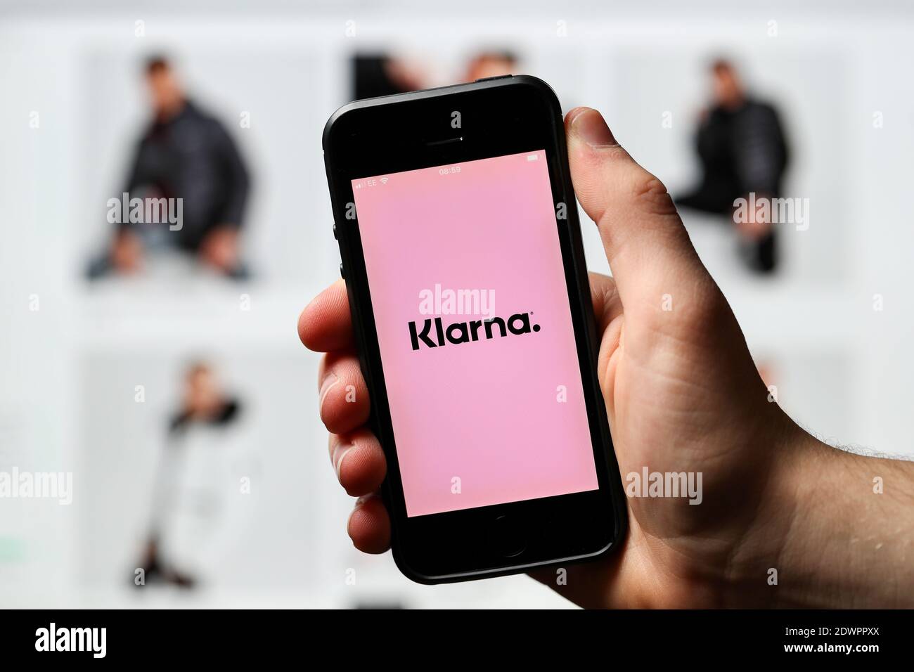 Ein Mann, der online einkauft und mit der Klarna App am Telefon bezahlt. Stockfoto