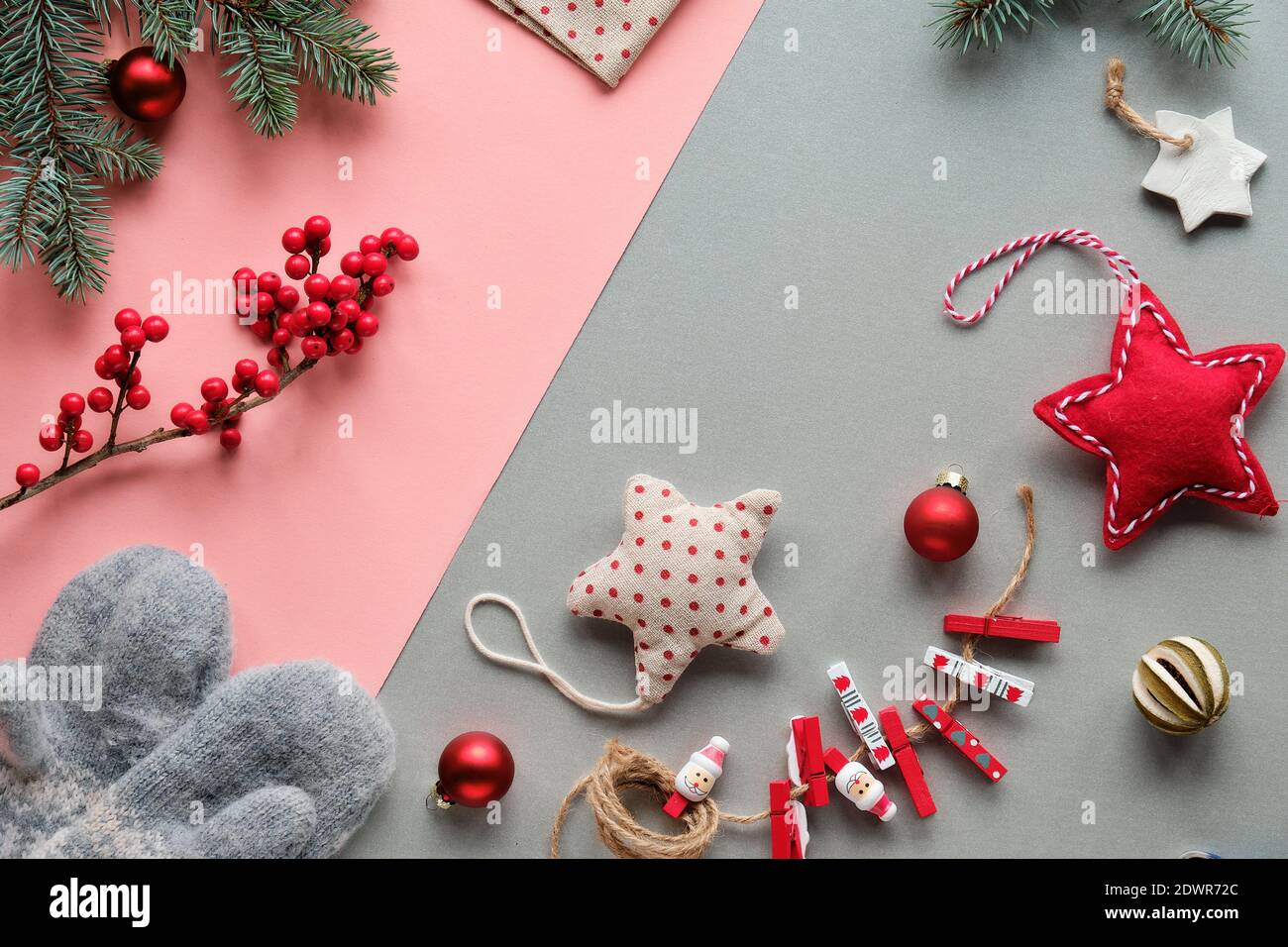 Nachhaltige Naturgeschenke für Zero Waste Weihnachten.Handschuhe, weiches Spielzeug, Holzpflöcke und natürliche Beeren. Papier in Lagenlook, pinkgrau, Draufsicht. Stockfoto