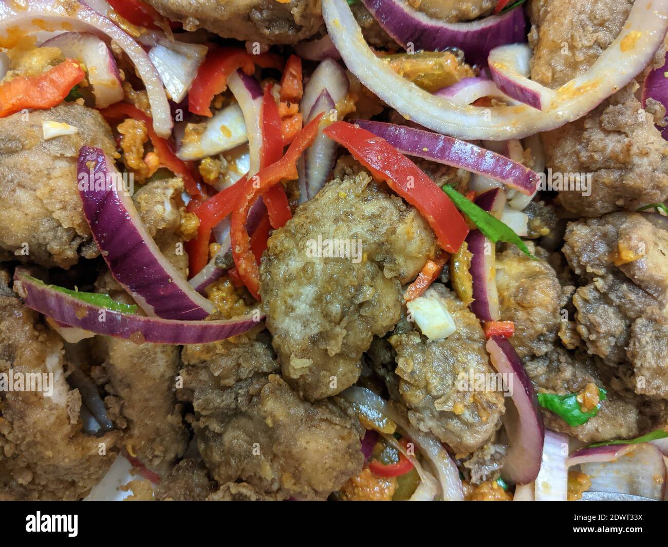 Zerschlagene würzige indische Hühnerstücke mit Chutney-Zwiebeln und Chilis Nahaufnahme Stockfoto