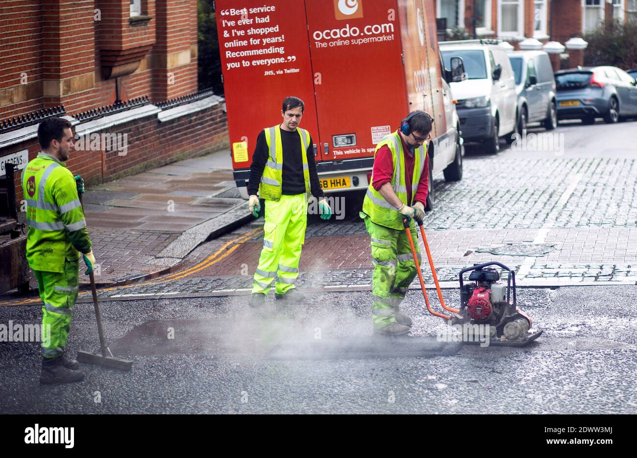 Bild zeigt: Team von Straßenarbeitern, die ein Schlagloch in der Straße in Highgate North London füllen Bild von Gavin Rodgers/ Pixel8000 Stockfoto