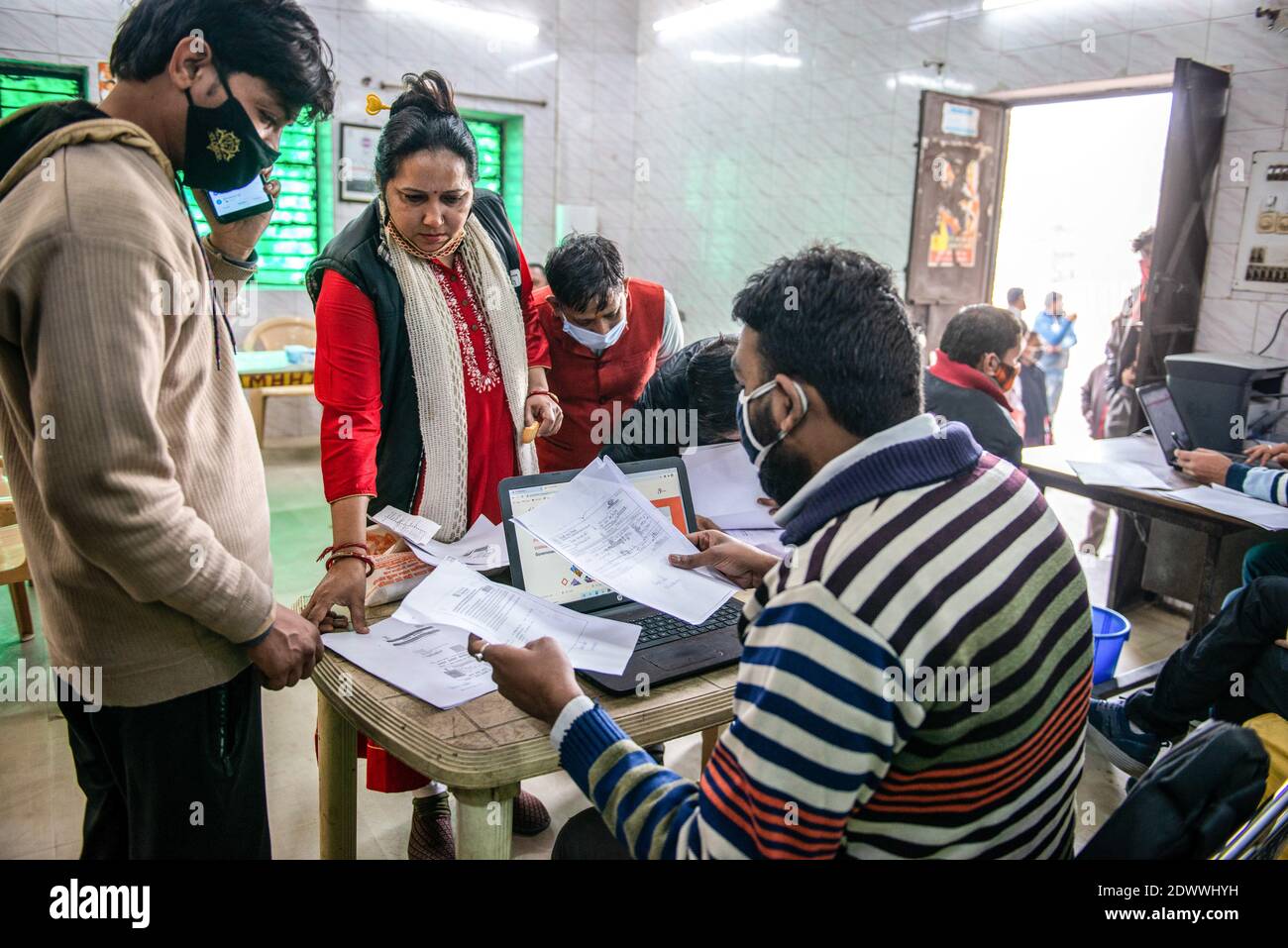 Neu Delhi, Indien. Dezember 2020. Freiwillige der Regierung, die Gesichtsmasken tragen, sammeln Dokumente von Straßenhändlern. DAS PROGRAMM PM SVANidhi wurde am 1. Juni 2020 vom Ministerium für Wohnungswesen und Stadtentwicklung ins Leben gerufen, um Straßenhändler, die von der Coronavirus-Pandemie betroffen waren, bei der Wiederaufnahme ihrer Lebensgrundlage zu unterstützen. Dies soll Straßenverkäufer stärken, indem sie ihnen nicht nur Kredite gewähren, sondern auch für ihre ganzheitliche Entwicklung und wirtschaftliche Hebung. Kredit: SOPA Images Limited/Alamy Live Nachrichten Stockfoto