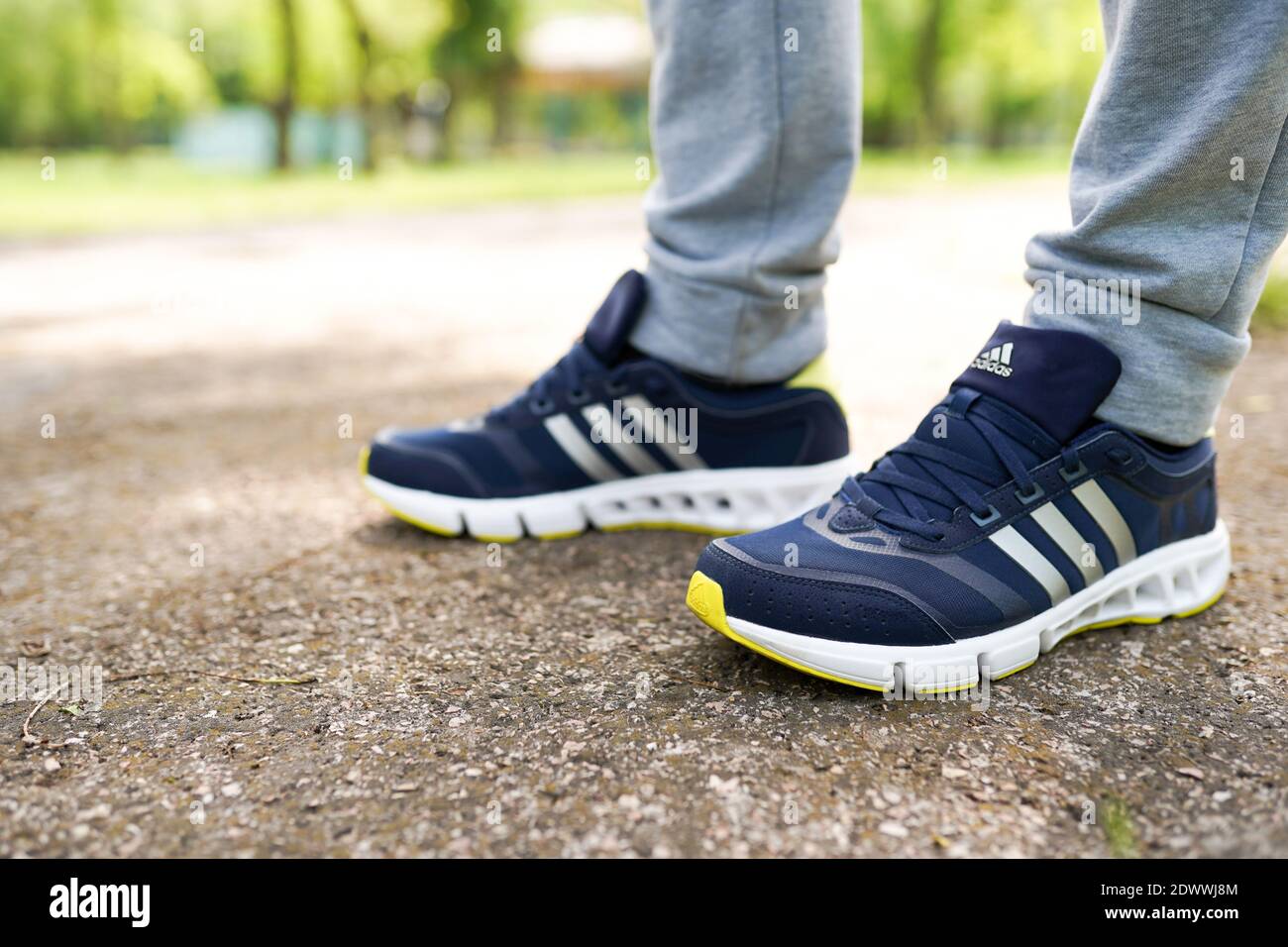 UKRAINE, ZAPOROZHYE - MAI 24, 2020 : männliche Füße in blauen Adidas-Schuhe im Freien Stockfoto