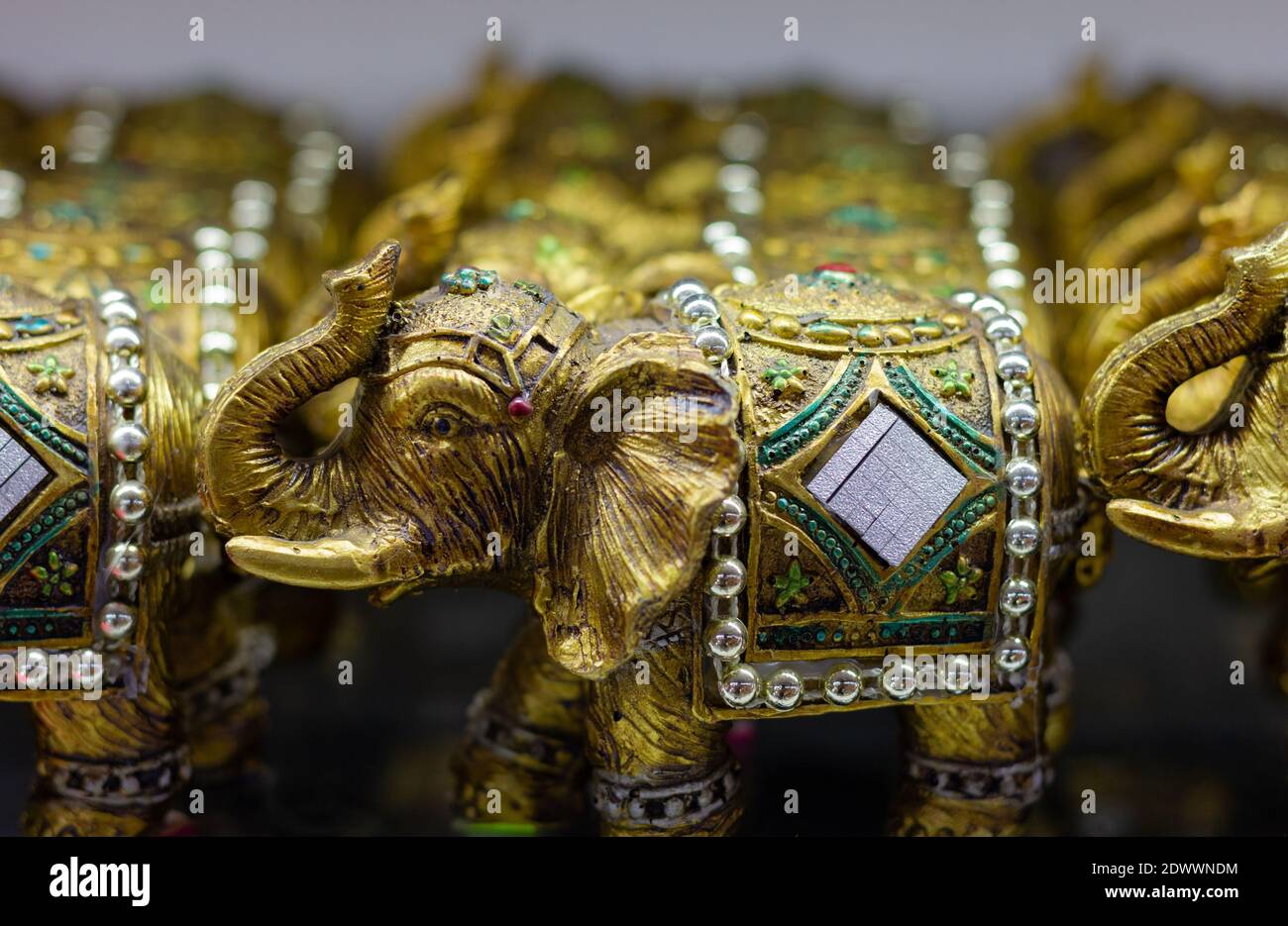 Goldfarbene Elefantenfiguren mit Rüssel nach oben. Souvenir Shop Geschenk, viel Glück Konzepte Stockfoto