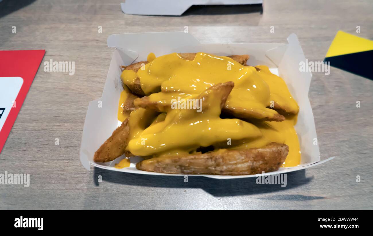 Kartoffelkeile mit Käse auf dem Holztisch. Selektiver Fokus Stockfoto