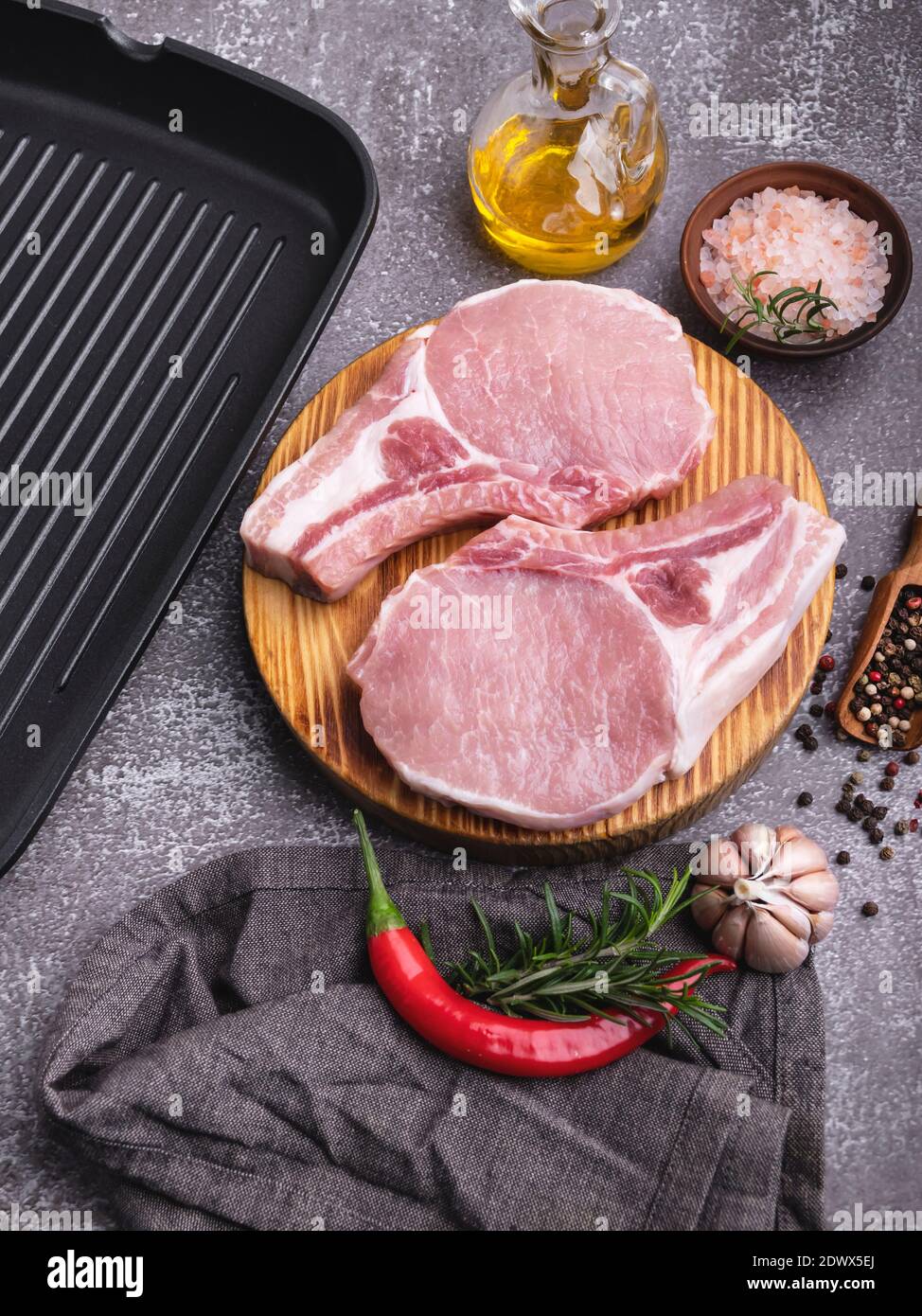 Frische rohe Stücke Fleisch Schweinefleisch, Rindfleisch, hacken auf einem Knochen auf dem Brett, Gewürze, Grillpfanne Stockfoto