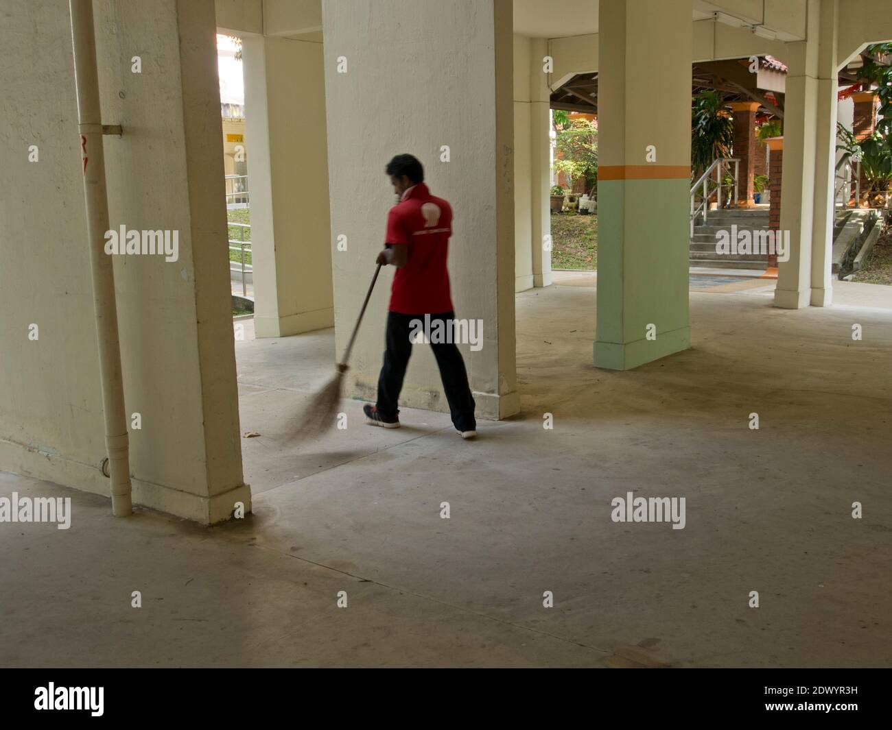 Bangladeschische Wanderarbeitnehmer, die Reinigungs- und Gartenarbeit bei tun Eine eingezäunte Wohnung in Singapur Stockfoto