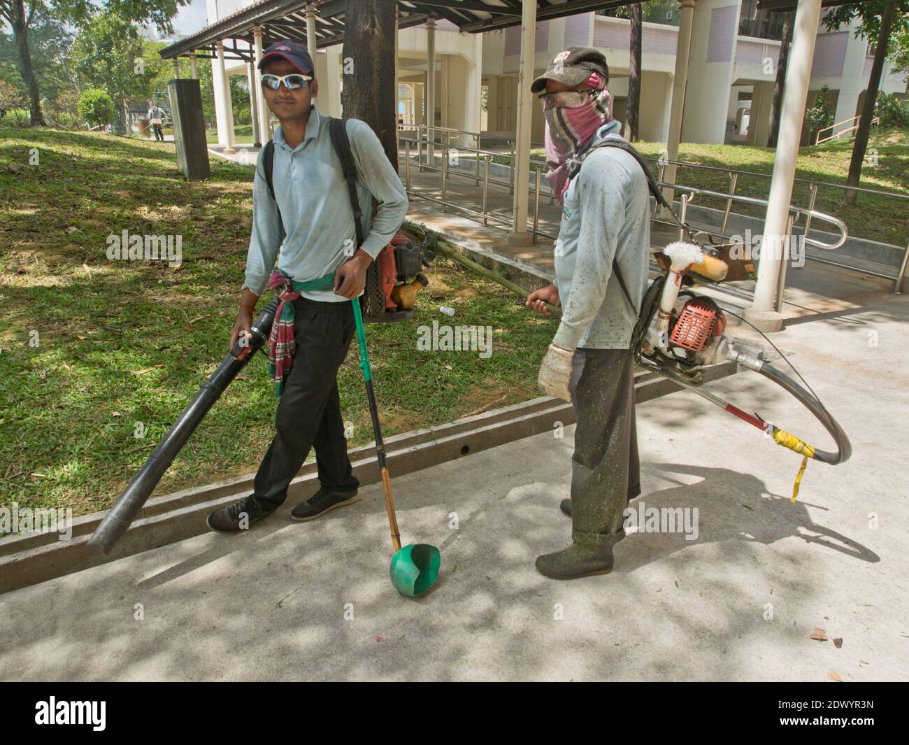 Bangladeschische Wanderarbeitnehmer, die Reinigungs- und Gartenarbeit bei tun Eine eingezäunte Wohnung in Singapur Stockfoto
