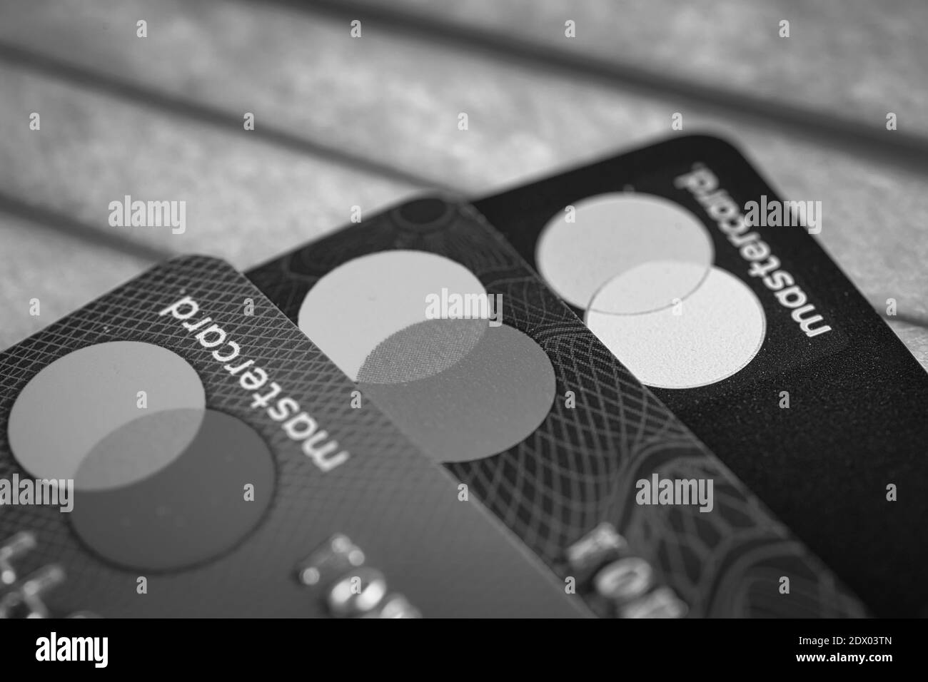 Mastercard Kreditkarten über einer schützenden Gesichtsmaske. Ein Schuldenkonzept während der Covid-19-Pandemie Stockfoto