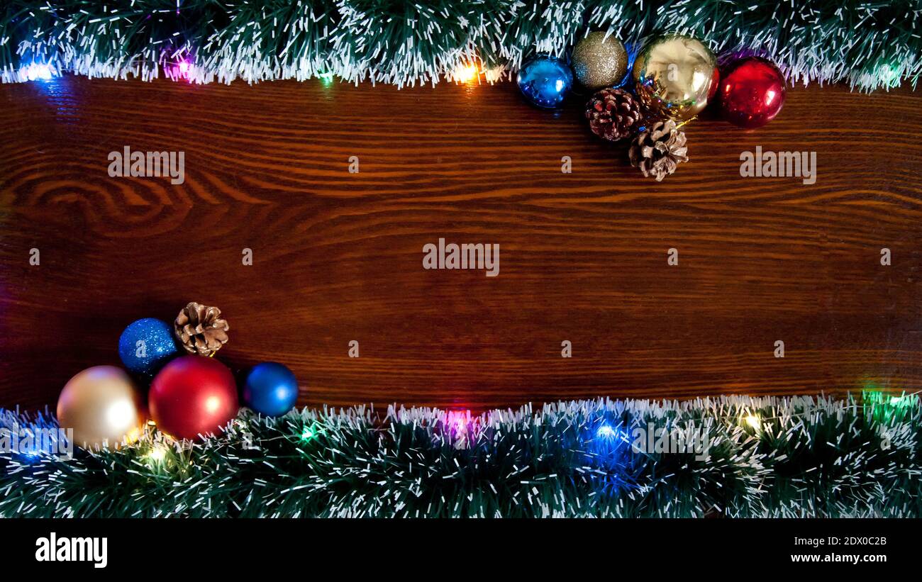 Weihnachten Hintergrund, ein Tisch mit Weihnachtsgirlande geschmückt.mit Neujahr und Weihnachten. Weihnachten rustikalen Hintergrund - altes Holz mit Lichtern und Fr. Stockfoto
