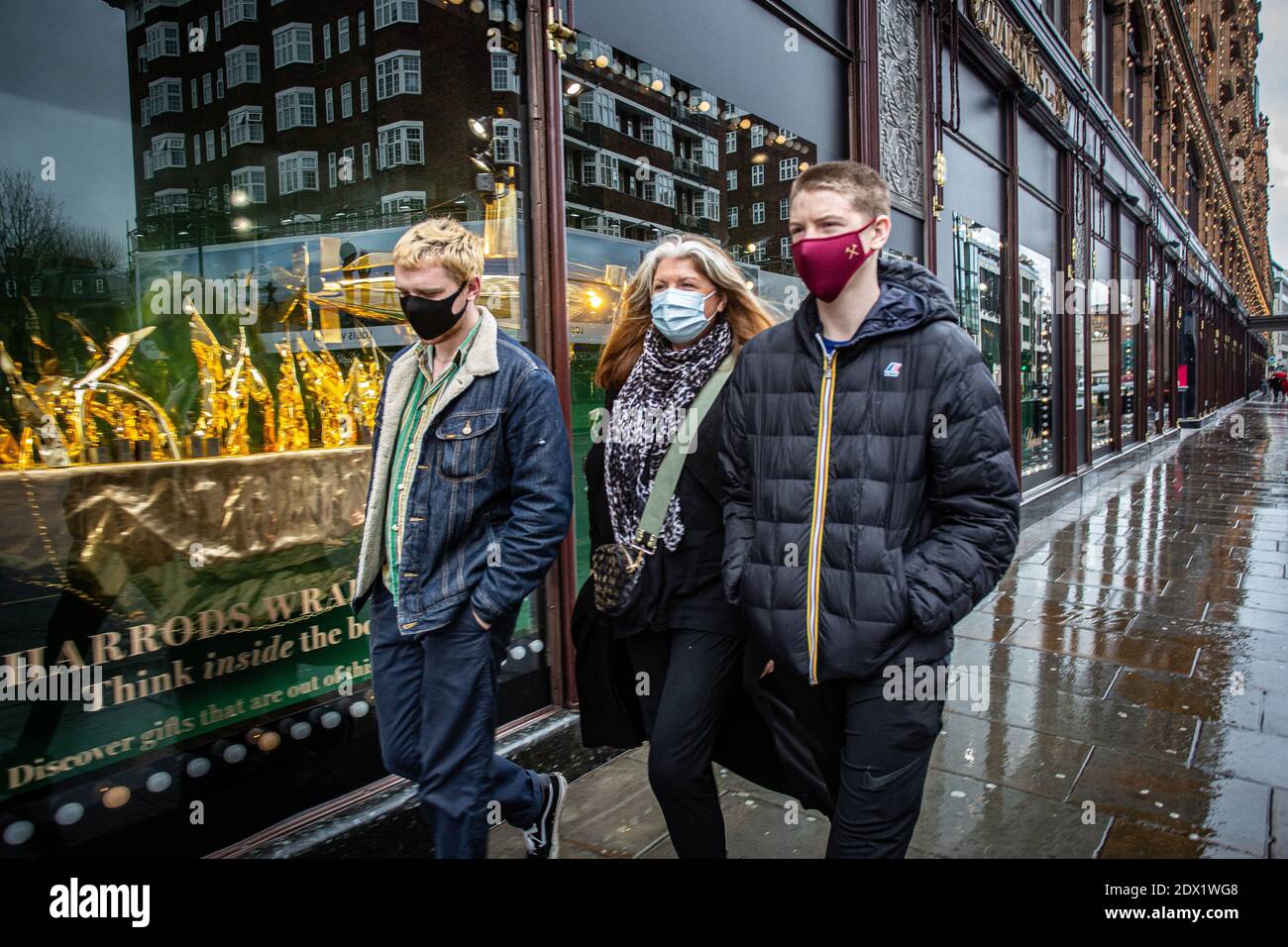 Großbritannien / England / London / EINE Familie mit Gesichtsmasken als Vorsichtsmaßnahme gegen das neuartige Coronavirus COVID-19 geht an Harrods vorbei. Stockfoto