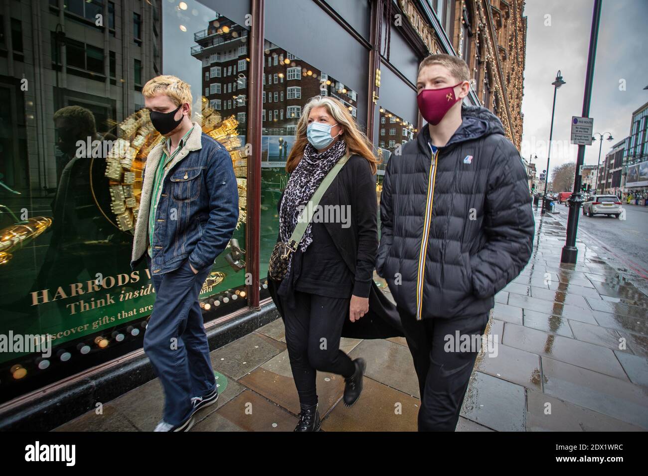 Großbritannien / England / London / EINE Familie mit Gesichtsmasken als Vorsichtsmaßnahme gegen das neuartige Coronavirus COVID-19 geht an Harrods vorbei. Stockfoto