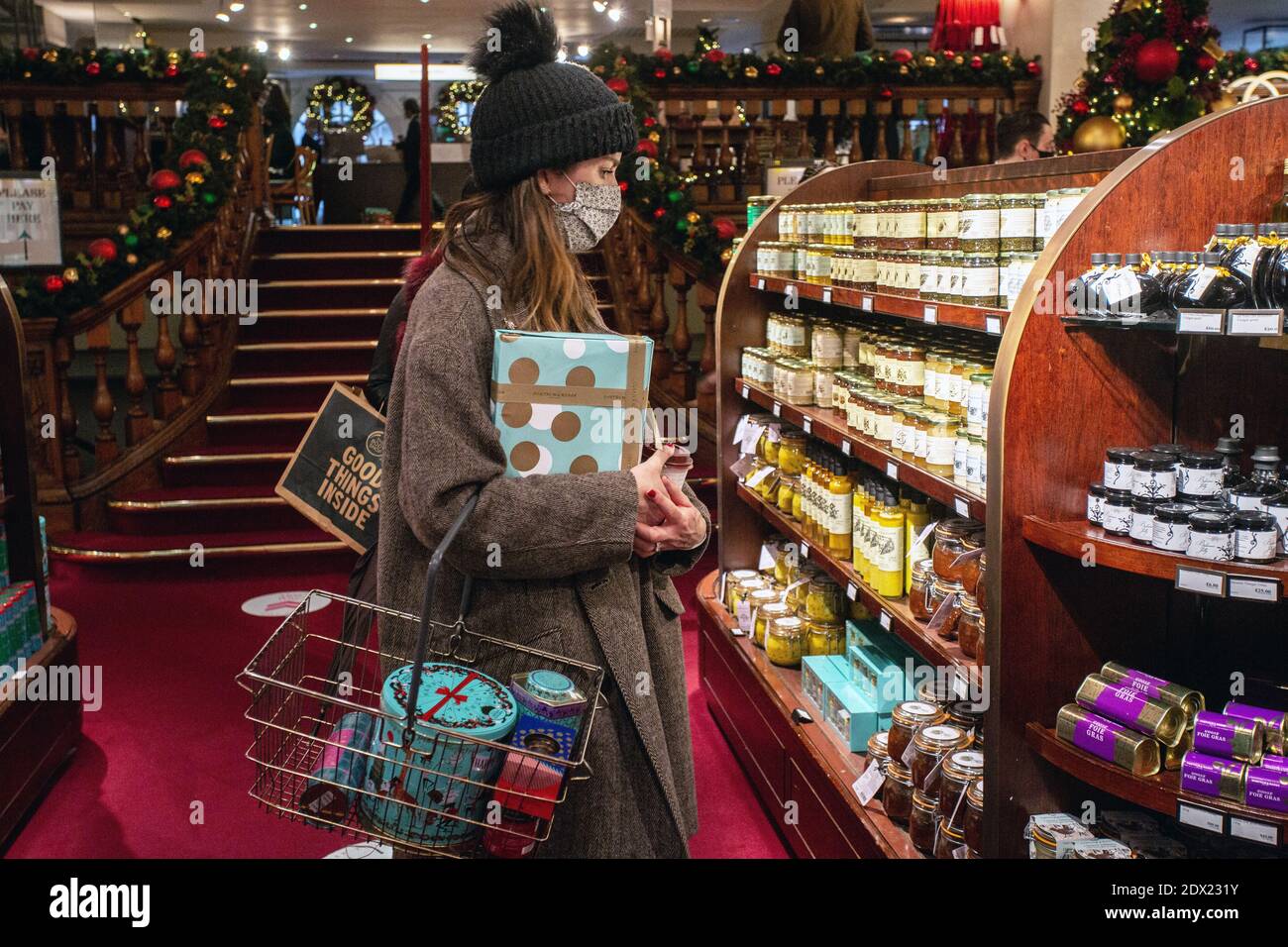 England /London/ Piccadilly/ Shopper trägt eine Gesichtsmaske wegen der COVID-19 Pandemie und kauft am 23. Dezember 2020 in Fortnum & Mason in London ein. Stockfoto England /London/ Piccadilly/ Shopper trägt eine Gesichtsmaske wegen der COVID-19 Pandemie und kauft am 23. Dezember 2020 in Fortnum & Mason in London ein. Stockfoto