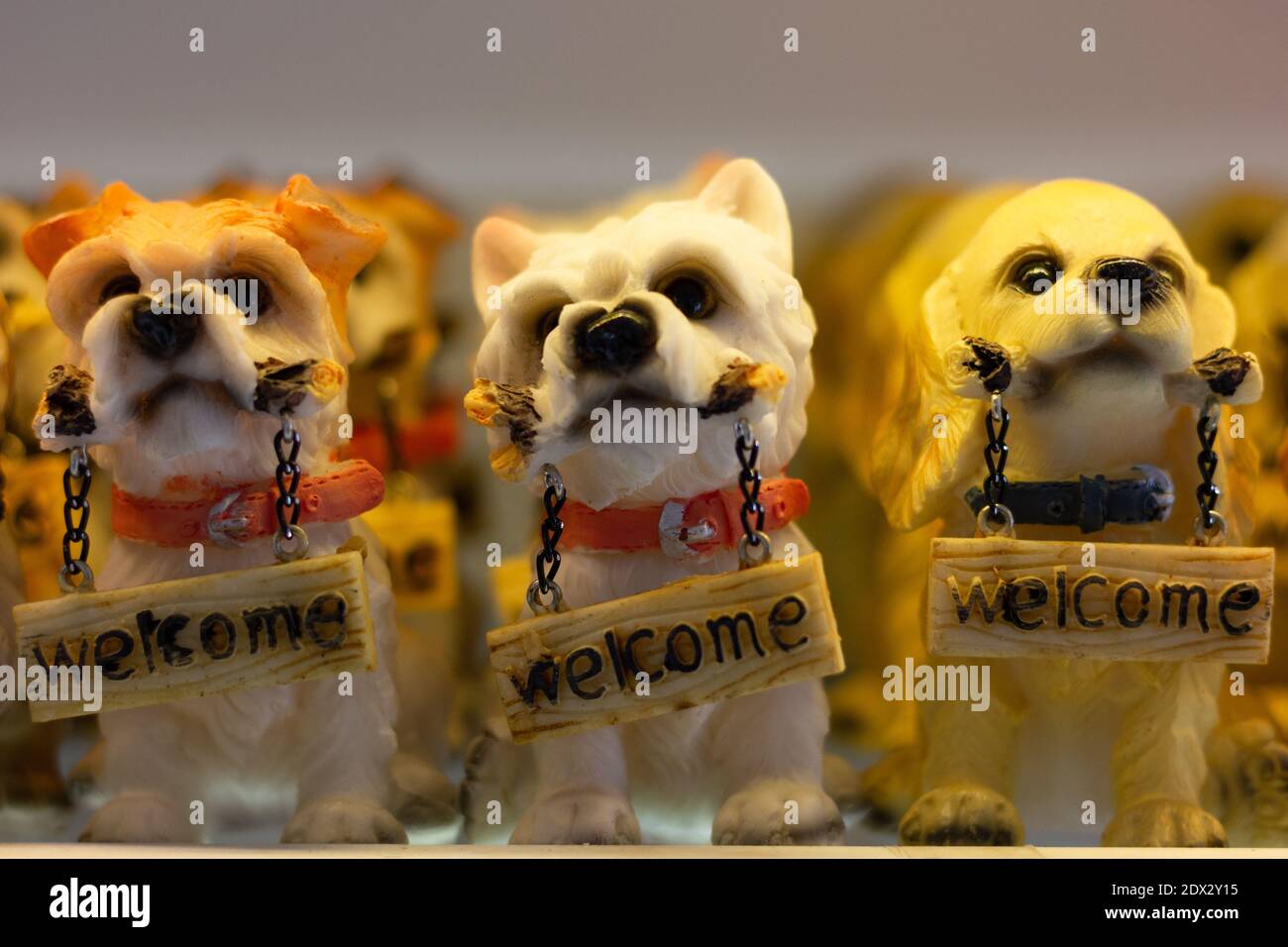 Kleine Hunde Figuren mit Willkommensschild. Niedliche Welpen Statuen, Souvenir-Shop Geschenkkonzepte Stockfoto