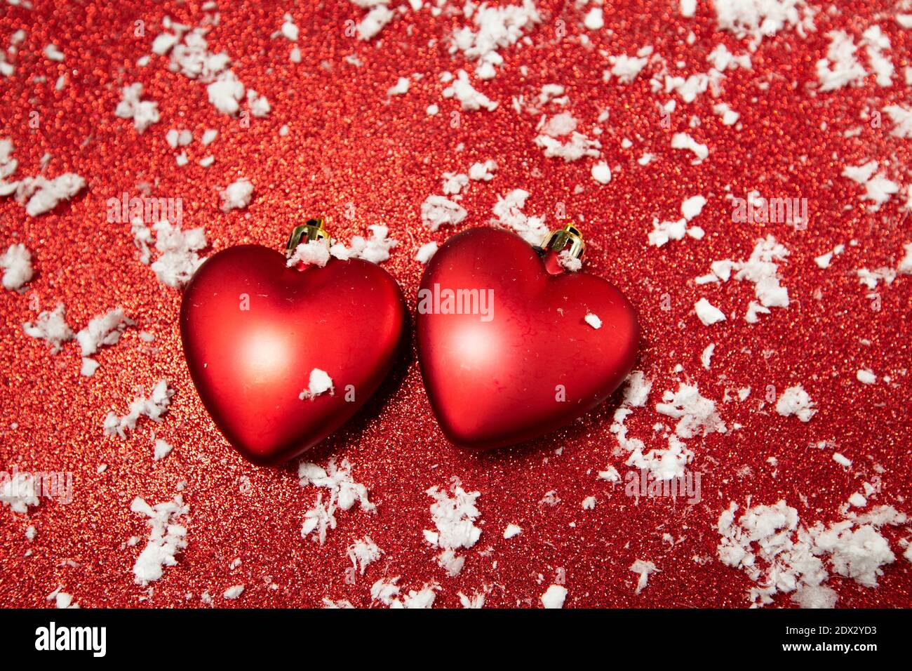 Rote Herzen auf rotem Hintergrund mit Schnee Stockfoto