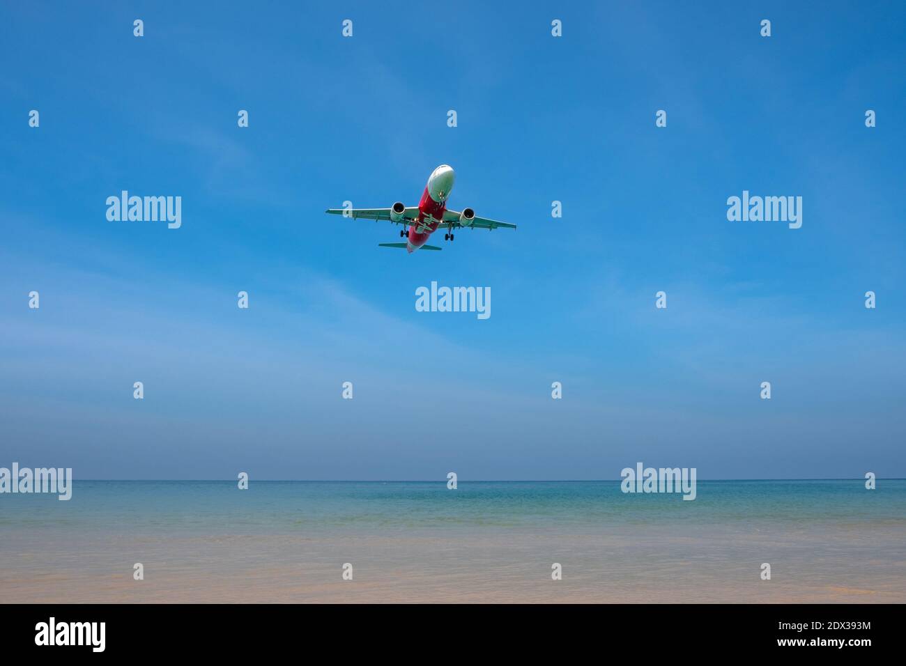 THAILAND, PHUKET, Mai Khao Beach - 03. MÄRZ 2018: Air Asia Flugzeug fliegt über das Meer. Das Flugzeug landet am Flughafen Phuket Stockfoto