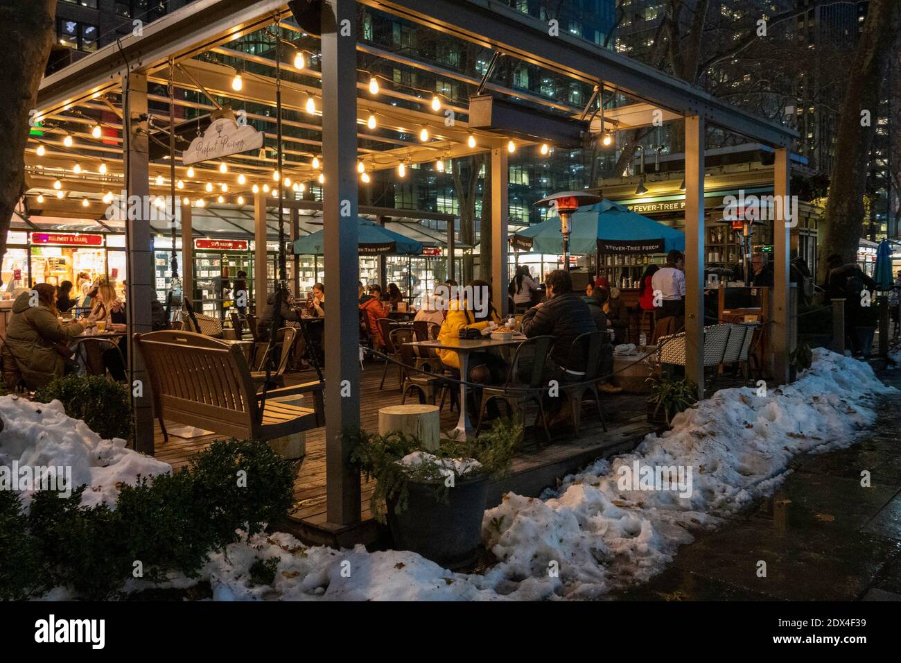 Fever-Tree Porch ist ein festlicher Ort für Mahlzeiten im Freien an einem verschneiten Abend im Bryant Park, New York City, USA Stockfoto