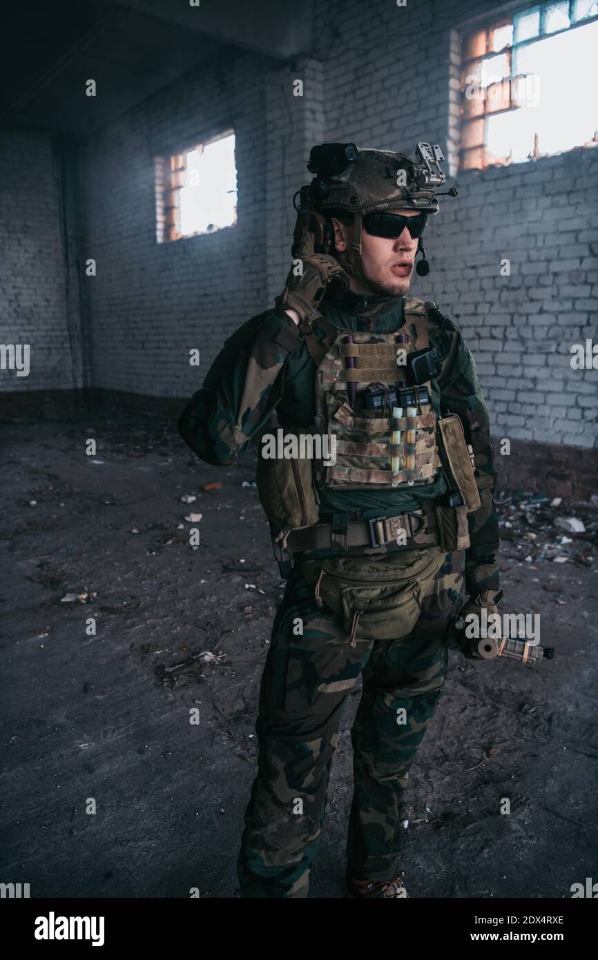 Soldat im Gespräch auf dem Walkie-Talkie im Gebäude, militärische Konzept Stockfoto