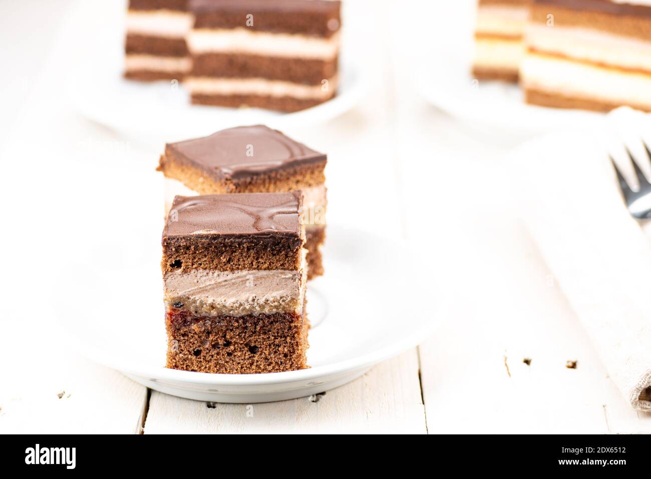 Schokoladenkuchen mit Kakaocreme-Füllung, Erdbeermarmelade und Walnussfüllung. Brauner Teig ist auch mit Kakao. Auf der Oberseite des Nachtisches ist Milchschokolade. Stockfoto