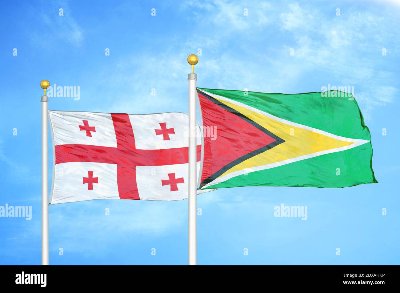 Georgien und Guyana zwei Flaggen auf Fahnenmasten und blauer Himmel Stockfoto