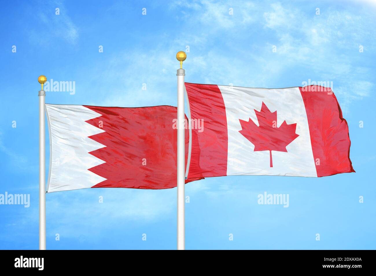 Bahrain und Kanada zwei Flaggen auf Fahnenmasten und blauer Himmel Stockfoto