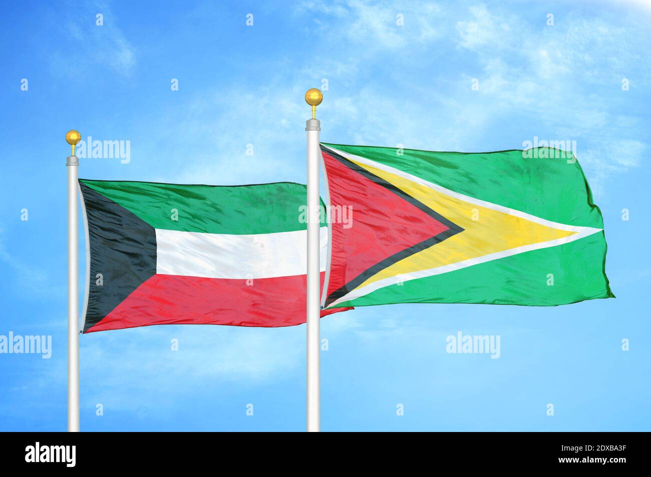 Kuwait und Guyana zwei Flaggen auf Fahnenmasten und blauer Himmel Stockfoto