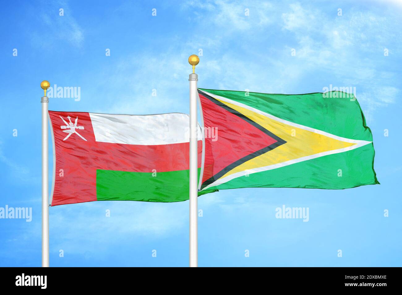 Oman und Guyana zwei Flaggen auf Fahnenmasten und blauer Himmel Stockfoto