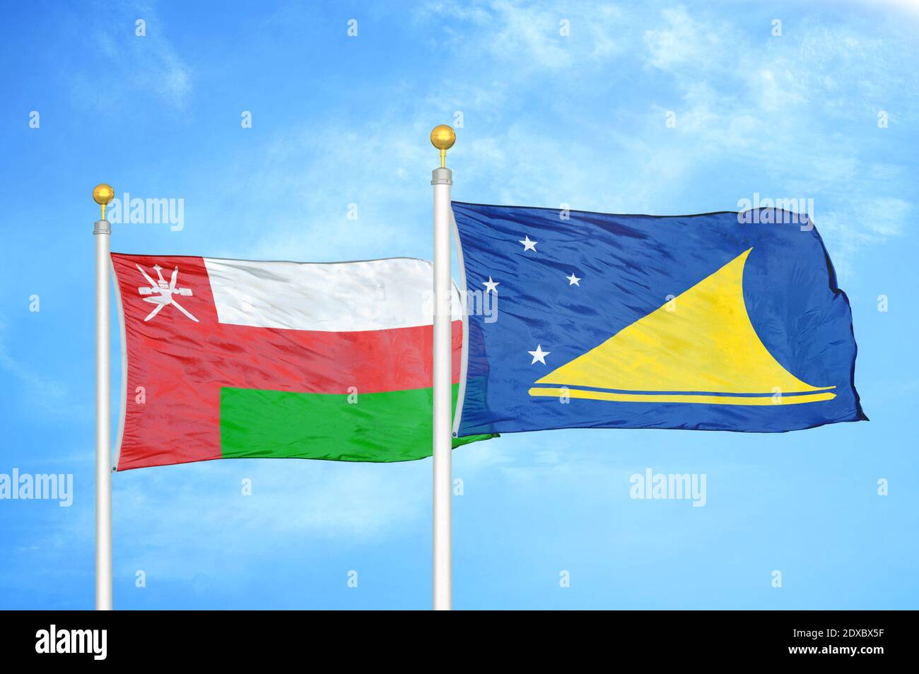 Oman und Tokelau zwei Flaggen auf Fahnenmasten und blauer Himmel Stockfoto