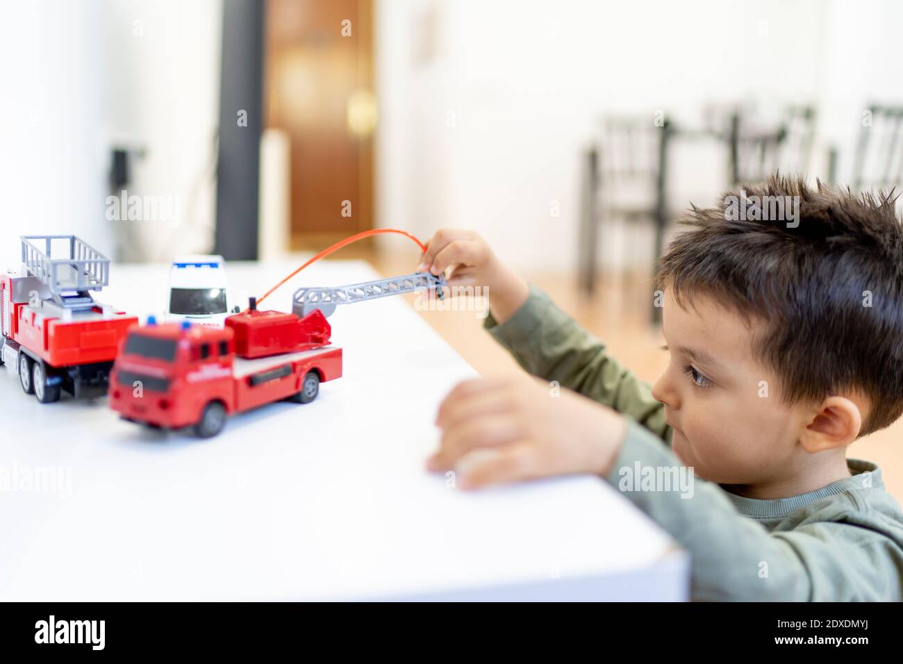 Junge spielt mit Feuerwehrspielzeug zu Hause Stockfoto