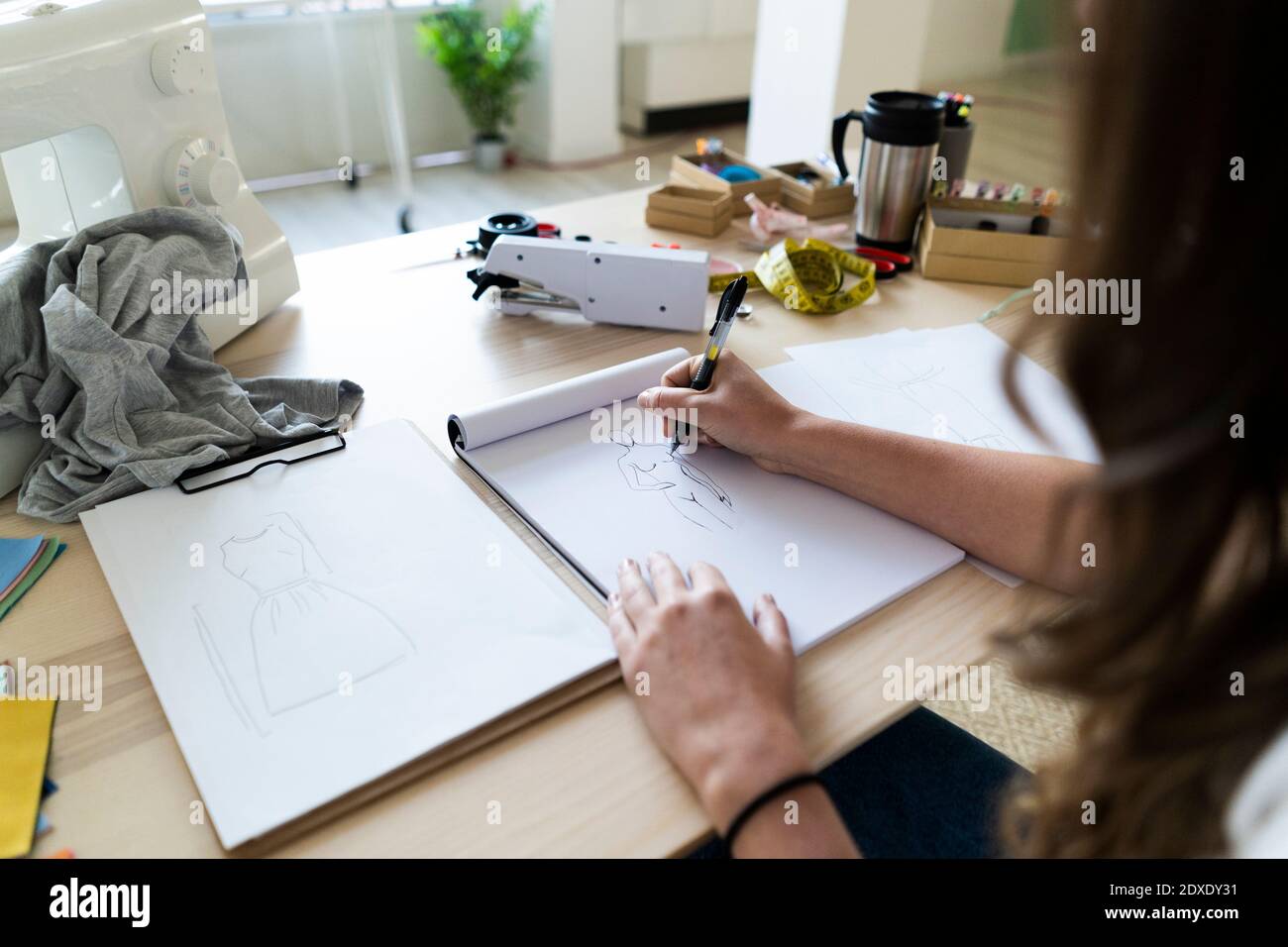 Junge kreative Designerin skizziert Design im Buch im Studio Stockfoto