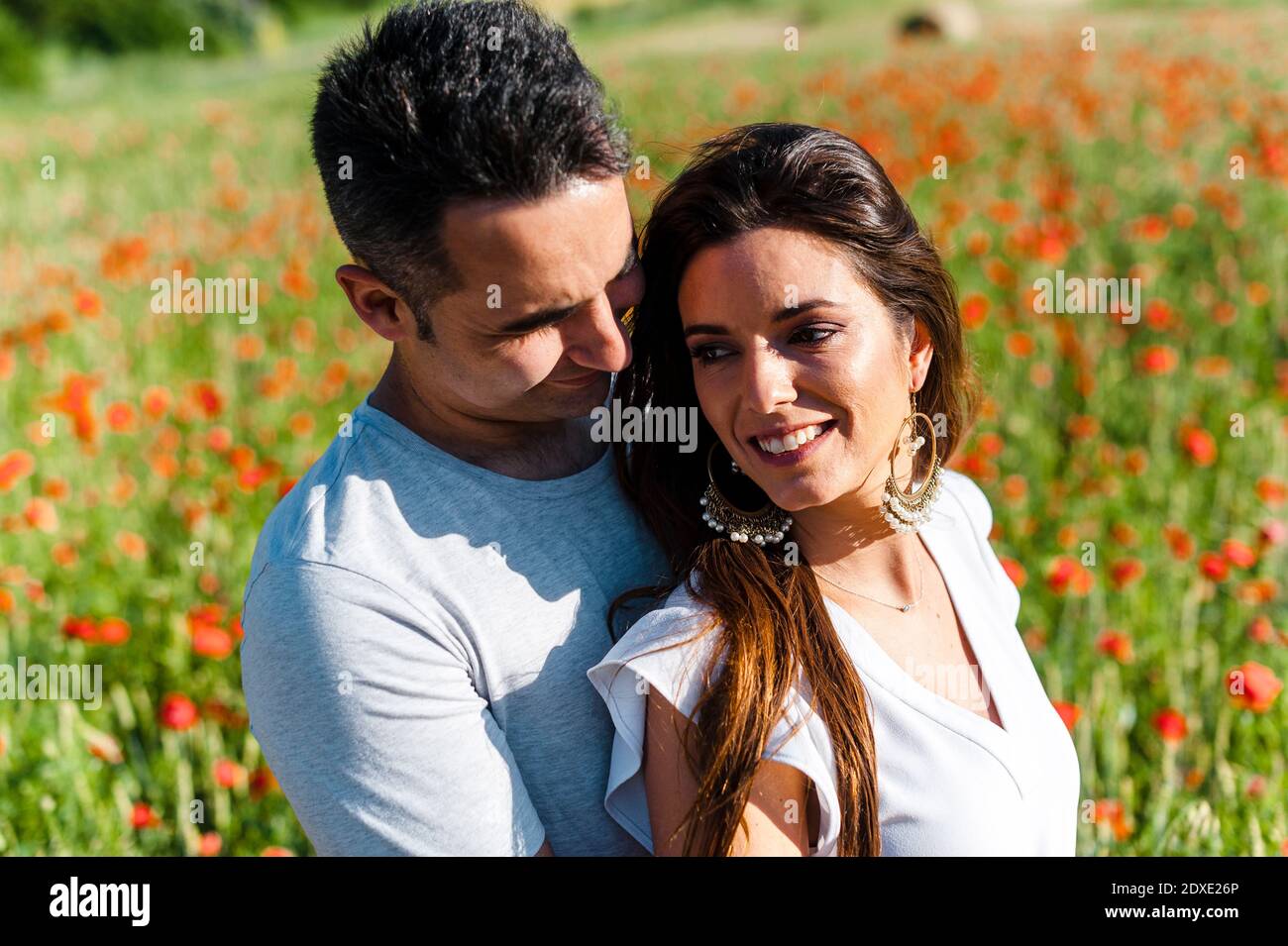 Glückliches heterosexuelles Paar auf dem Mohn Feld Stockfoto