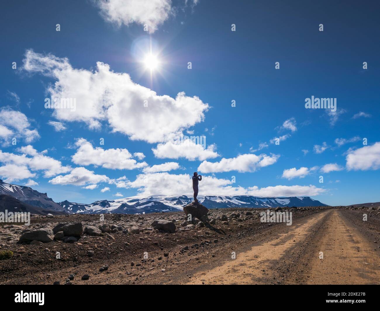 Männlicher Forscher, der auf einem Felsobjekt gegen den wolkigen Himmel steht, Langjokull, Island Stockfoto