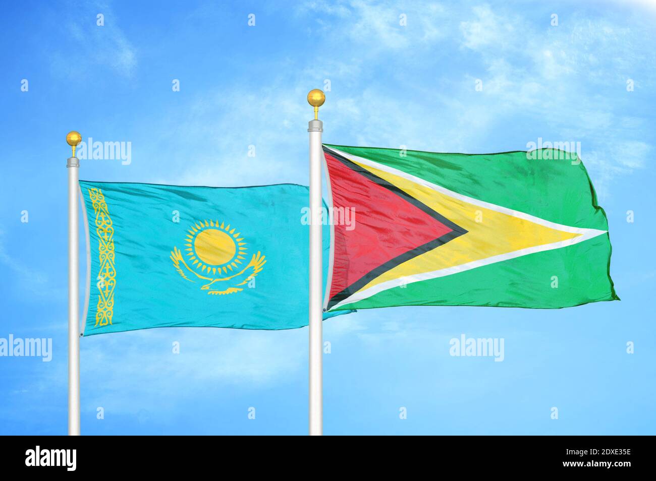 Kasachstan und Guyana zwei Flaggen auf Fahnenmasten und blauer Himmel Stockfoto