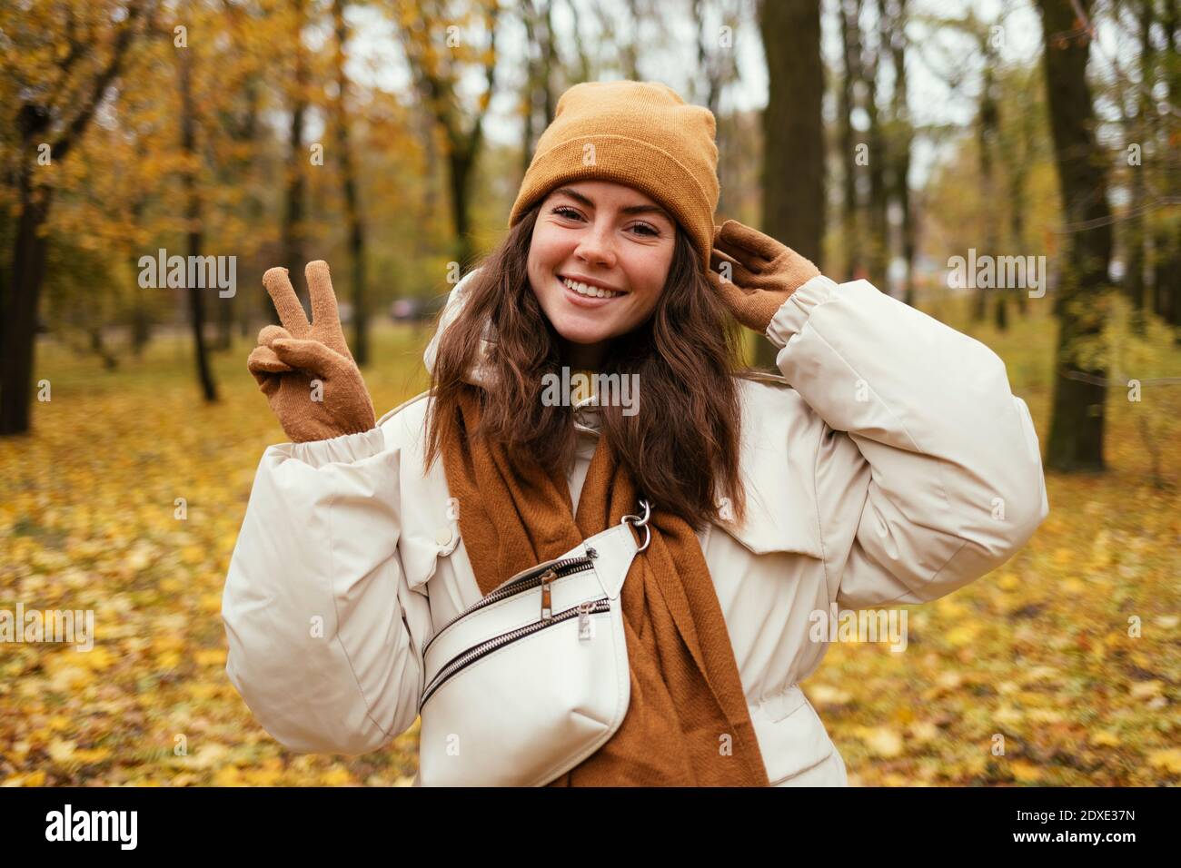 Glückliche junge Frau Frieden gestikuling im Herbst Park Stockfoto