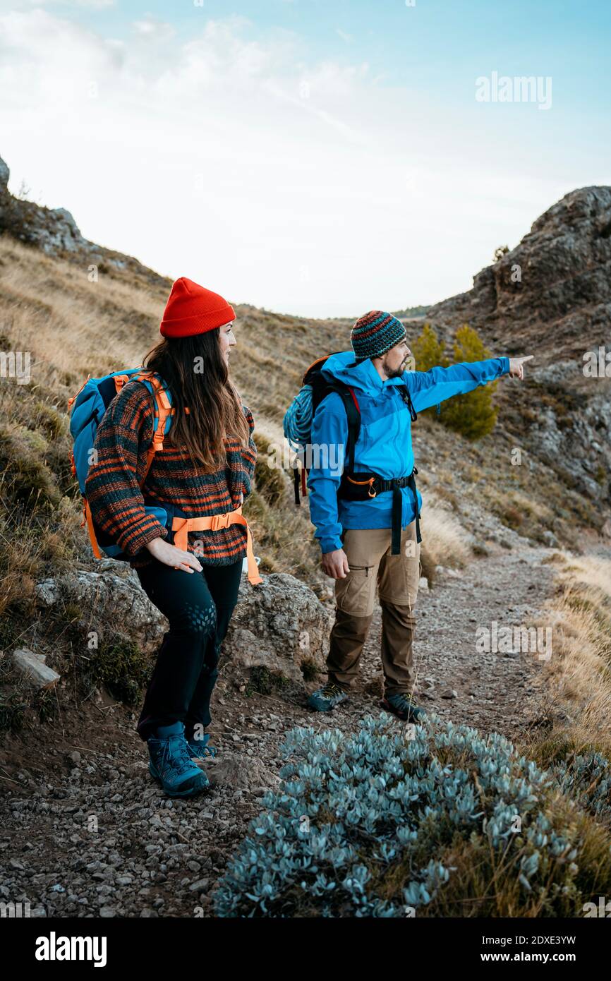 Mittelerwachsener Mann zeigt beim Wandern mit Freundin auf Rocky Berg im Urlaub Stockfoto