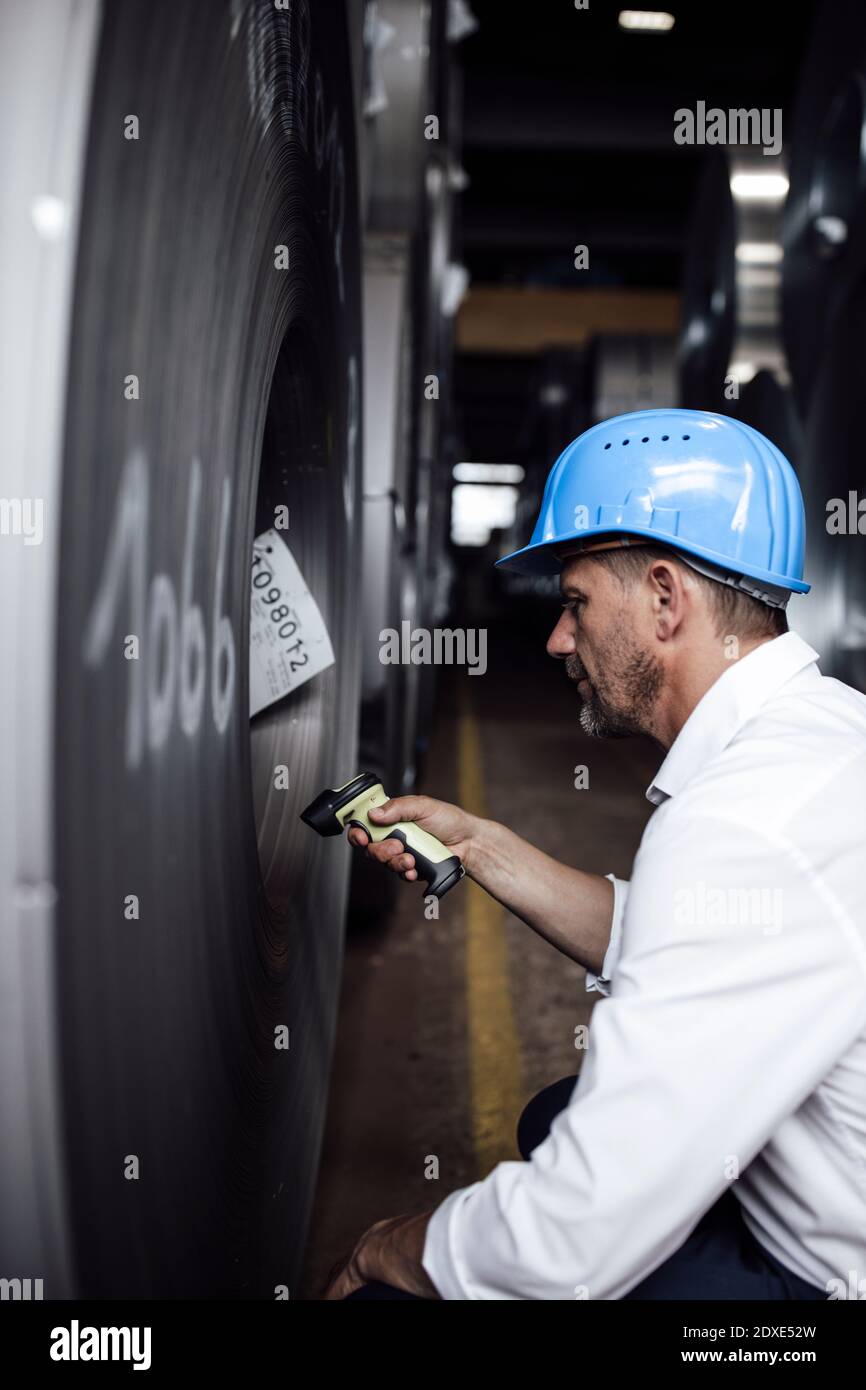 Geschäftsmann Scannen Barcode auf Stahlrollen, während in der Industrie stehen Stockfoto