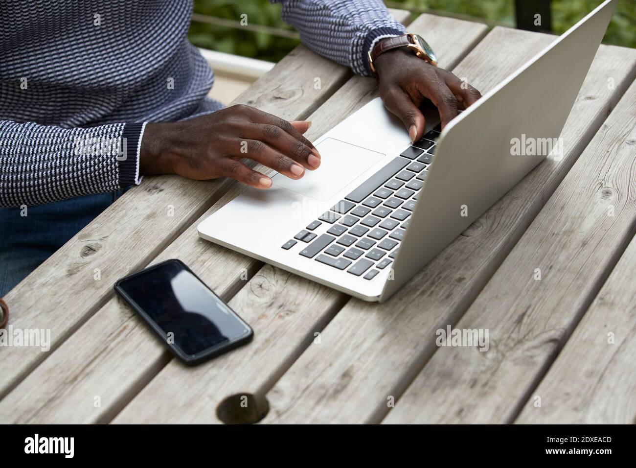 Männlich professionell mit Laptop an Holztisch Stockfoto