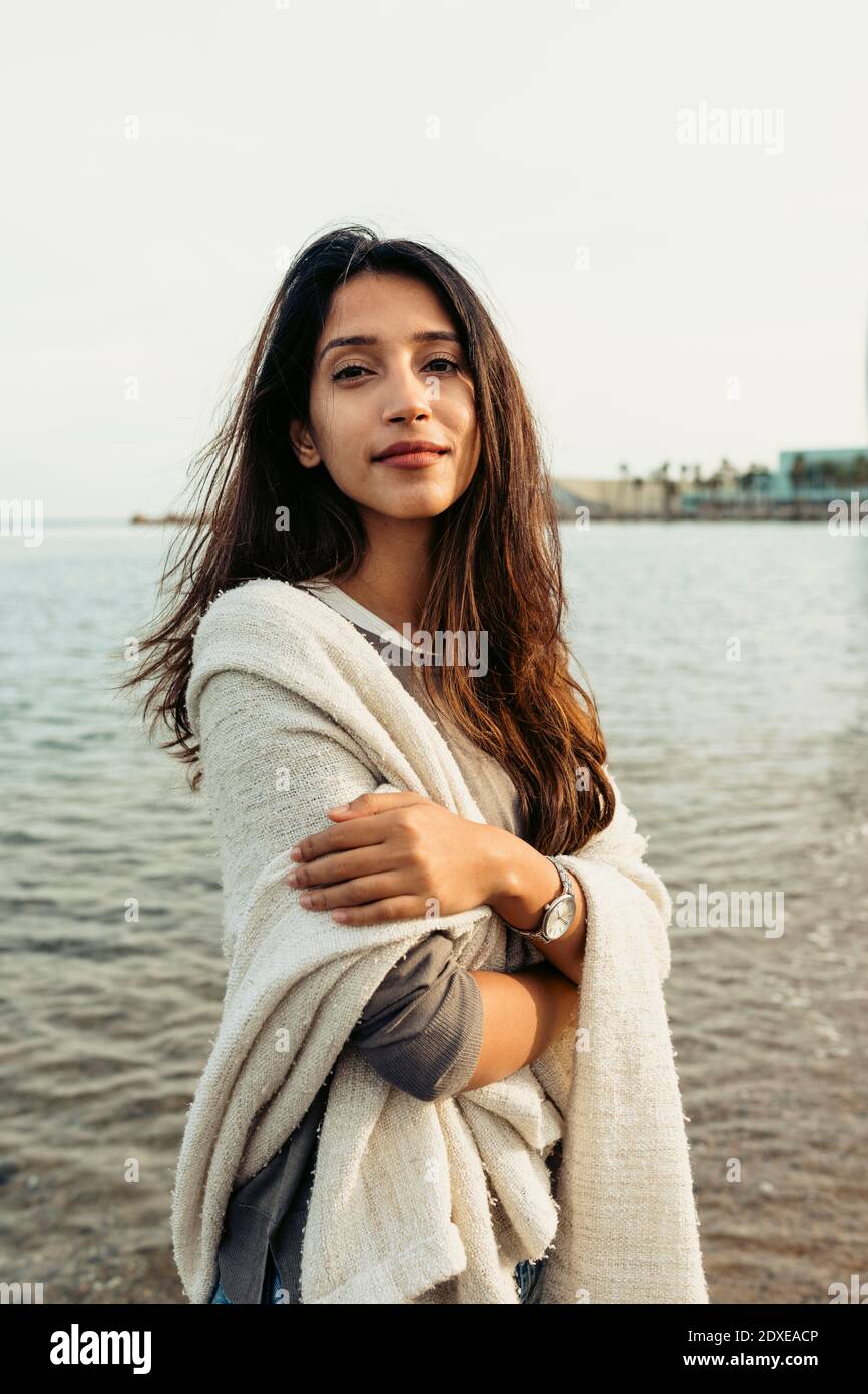 Schöne Frau mit gekreuzten Armen stehen am Strand Stockfoto