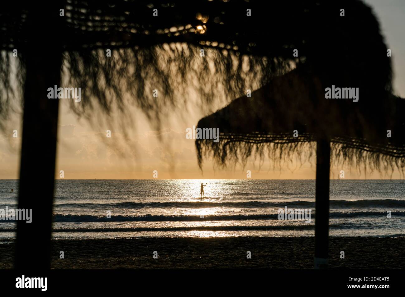 Silhouette Frau Surfen mit Paddleboard auf dem Meer bei Sonnenaufgang Stockfoto