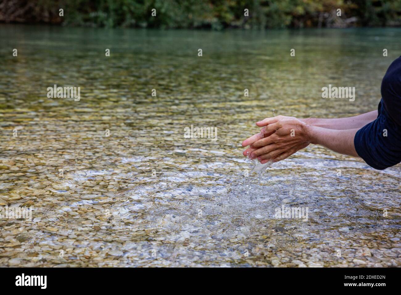 Mann, der sich im Acheron River bei Epirus, Griechenland, die Hände wäscht Stockfoto