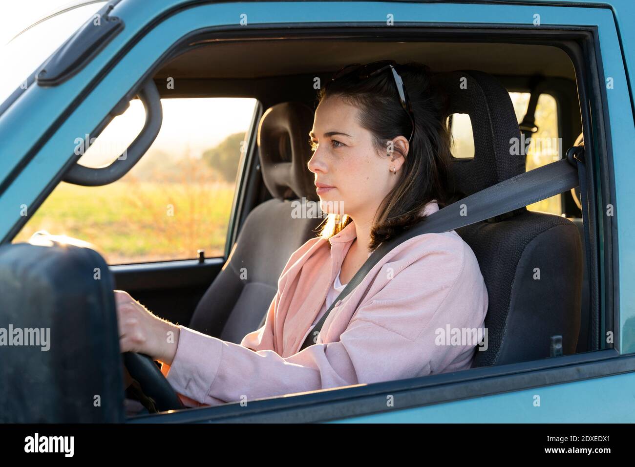 Junge Frau, die auf der Autoreise Auto fährt Stockfoto