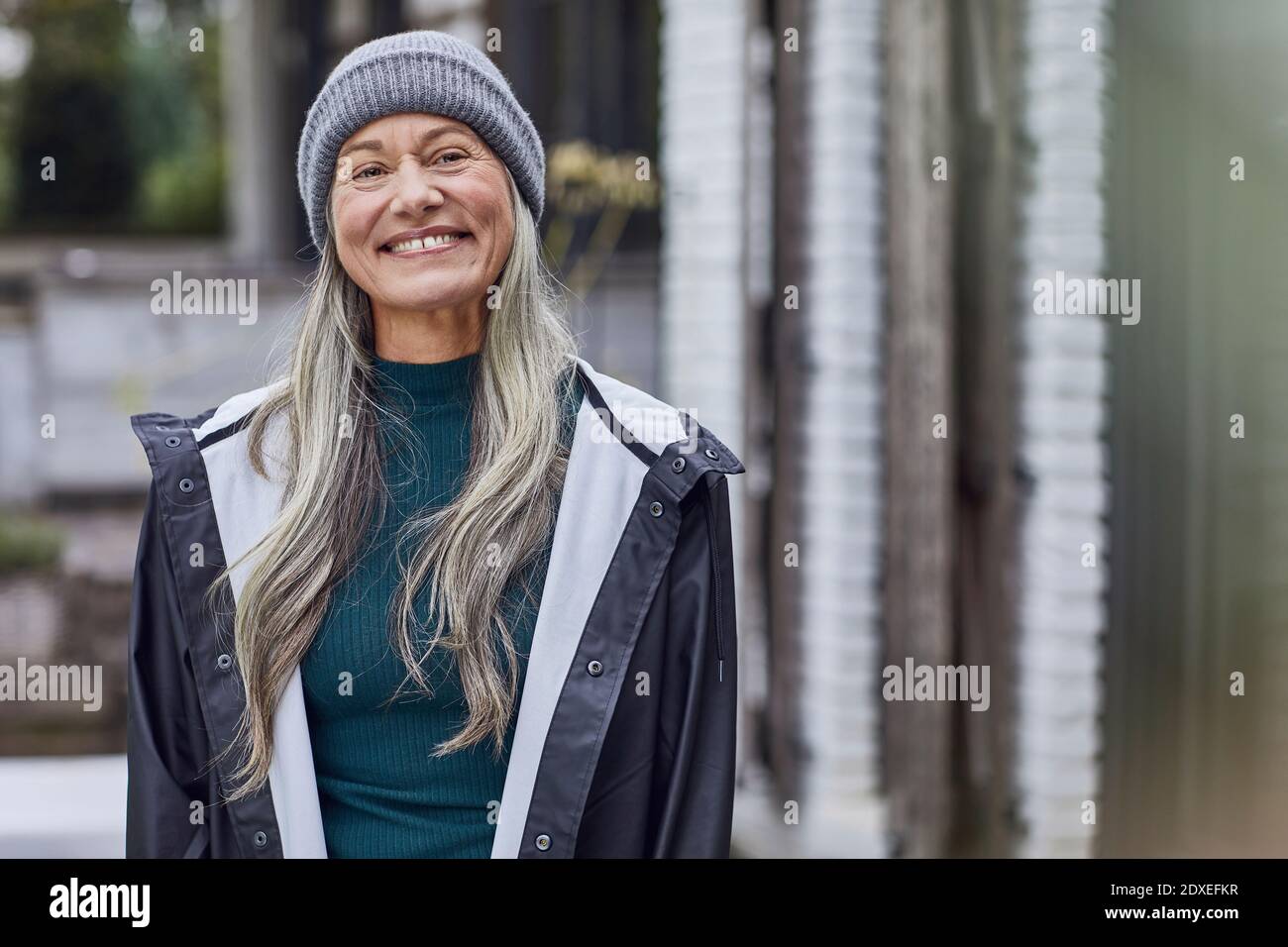 Glückliche reife Frau mit grauen Haaren im Hinterhof Stockfoto