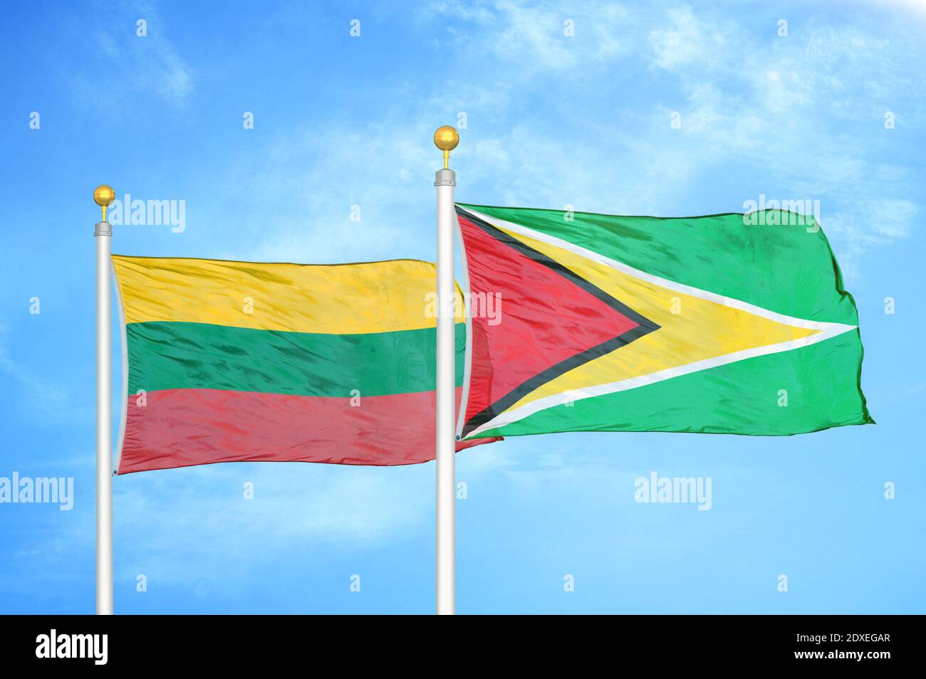 Litauen und Guyana zwei Flaggen auf Fahnenmasten und blauer Himmel Stockfoto