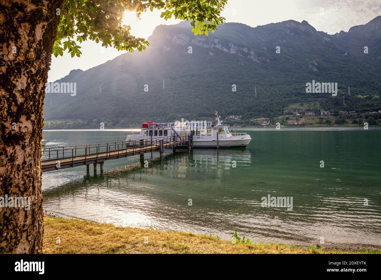 Schiff in der Nähe von Steg am Idrosee gegen Berg Stockfoto