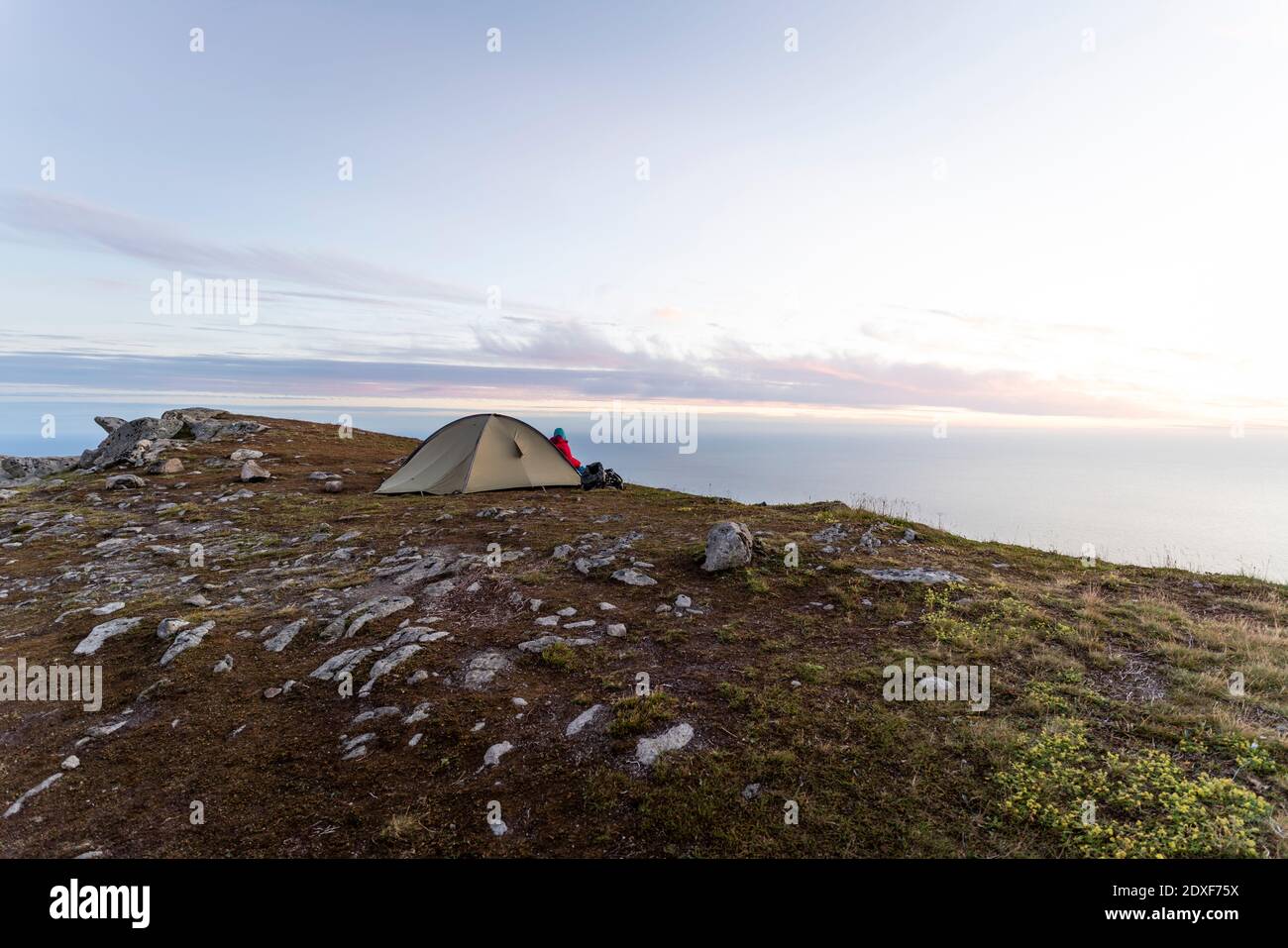 Frau sitzt im Zelt auf dem Berg in Ryten, Lofoten, Norwegen Stockfoto