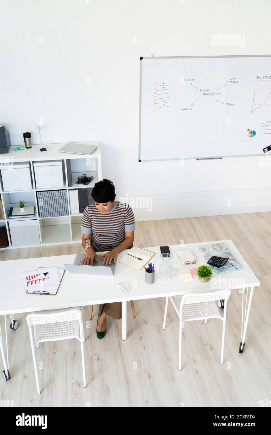 Geschäftsfrau, die allein am Bürotisch arbeitet Stockfoto