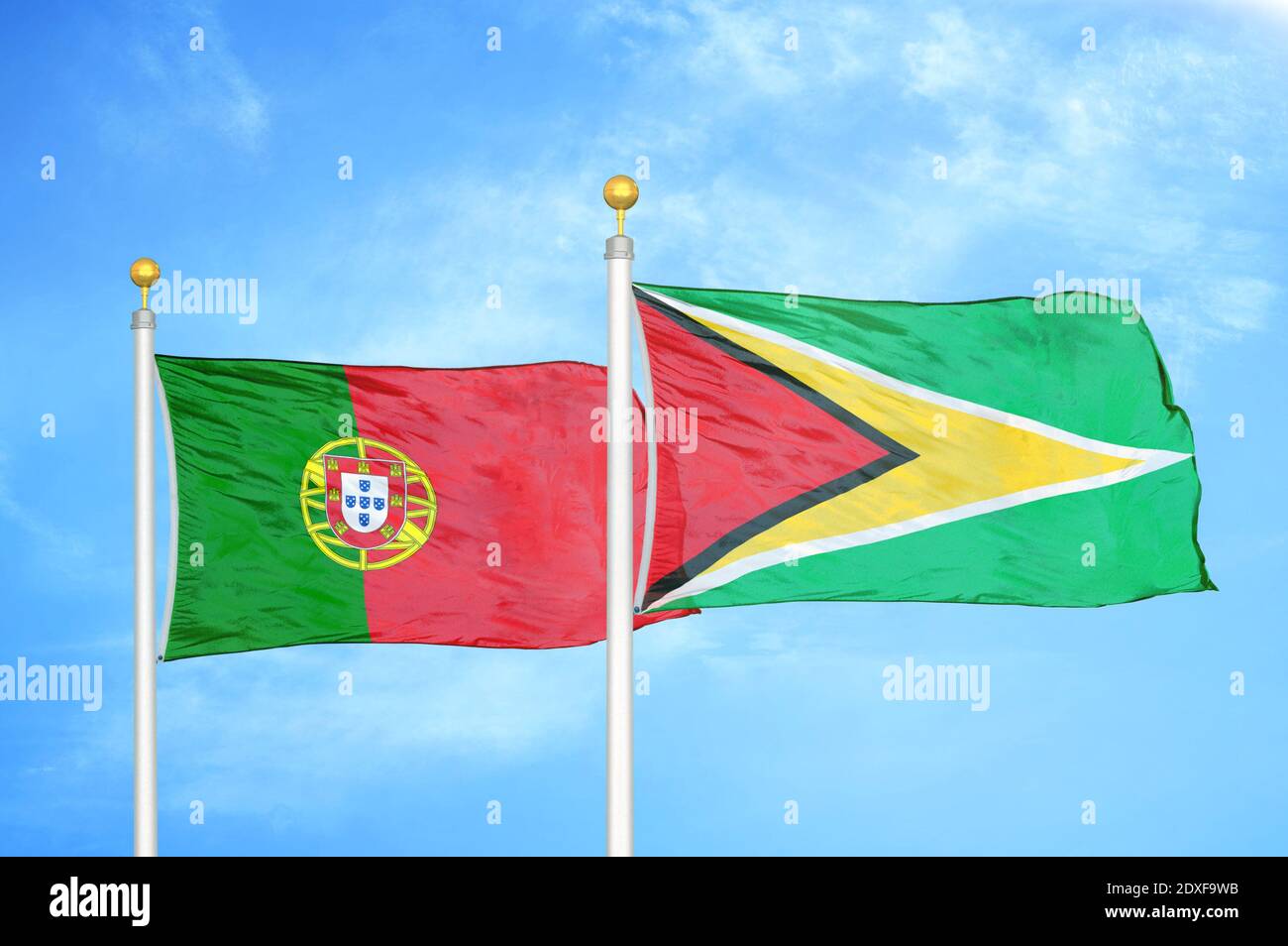 Portugal und Guyana zwei Flaggen auf Fahnenmasten und blauer Himmel Stockfoto